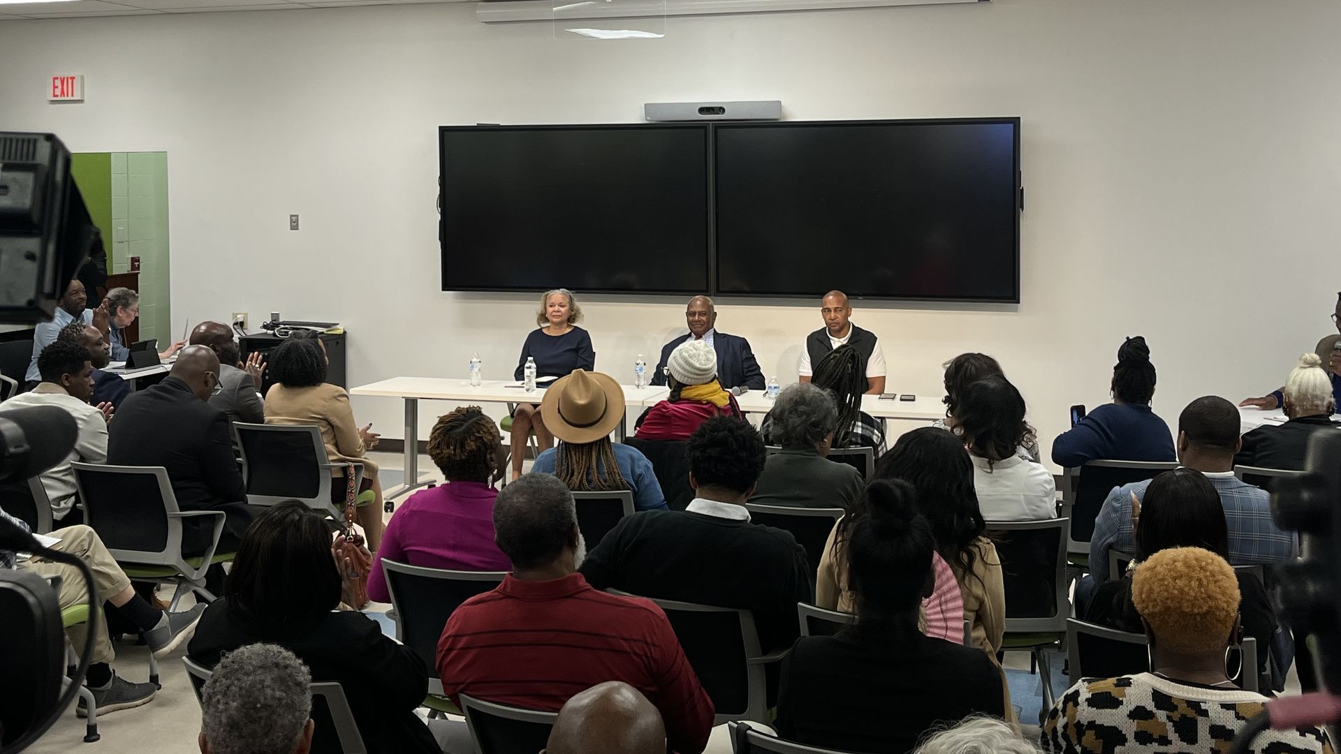 Tuesday's panel drew a packed room to hear from Charlotte's current and former mayors. Seated left to right: Vi Lyles, Harvey Gantt and Patrick Cannon. Anthony Foxx joined briefly via Zoom. Photo: Alexandria Sands/Axios