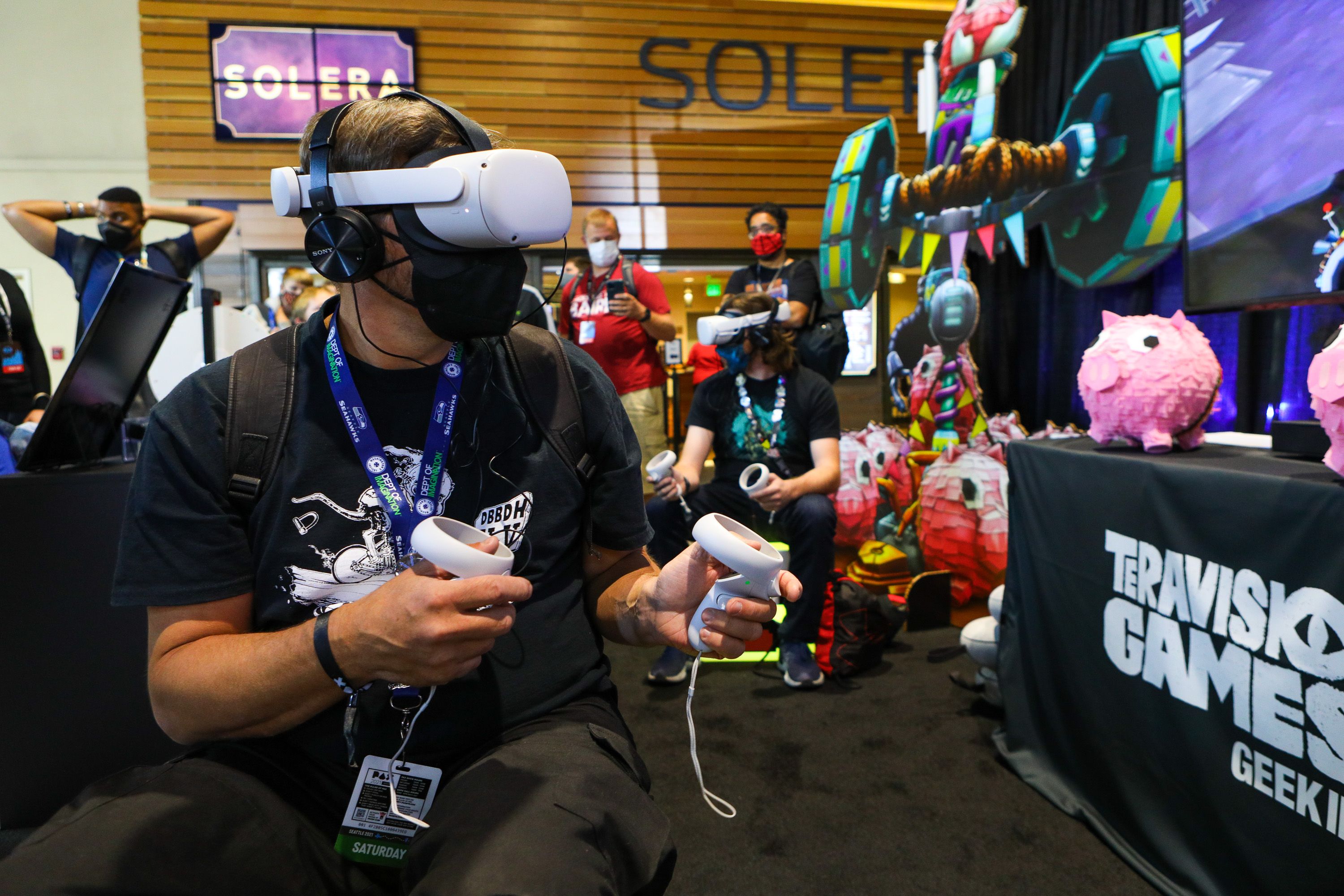 A person with a virtual reality headset plays a game at PAX West. 