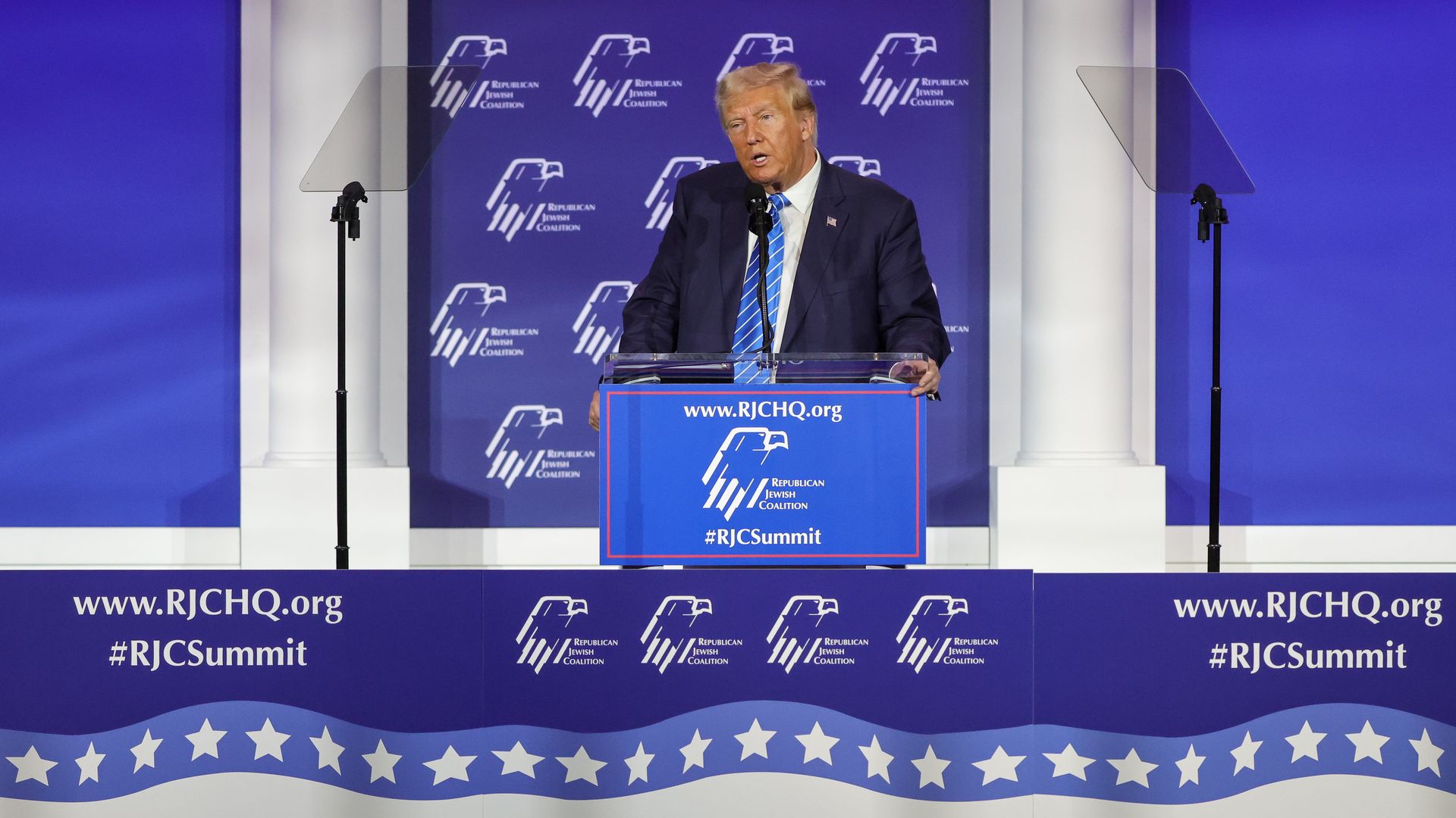 Trump speaks at a campaign event in front of a blue lectern and blue backdrop