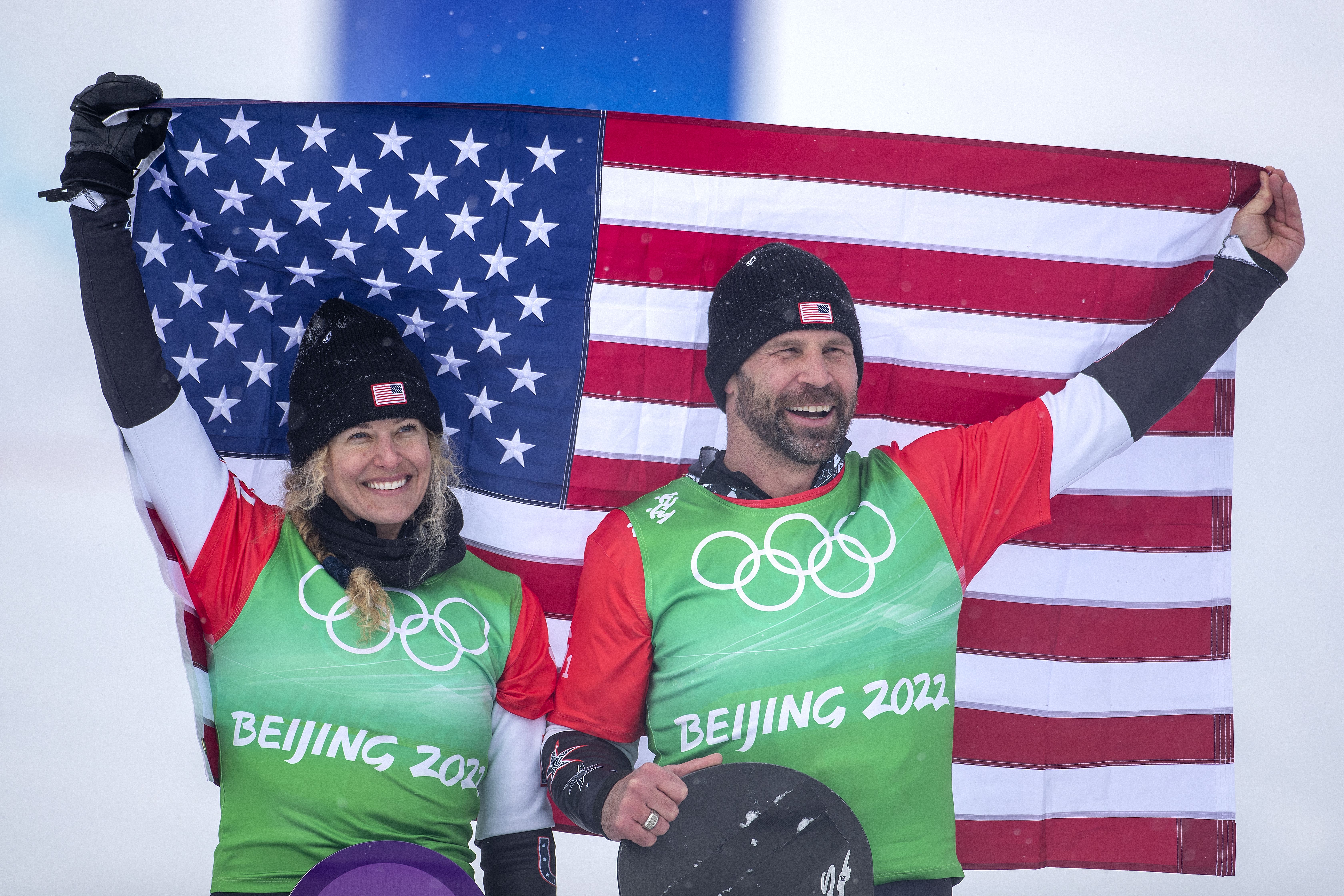 Lindsey Jacobellis and Nick Baumgartner celebrate their gold medal win during the mixed team snowboard cross during the 2022 Olympic Winter Games. 