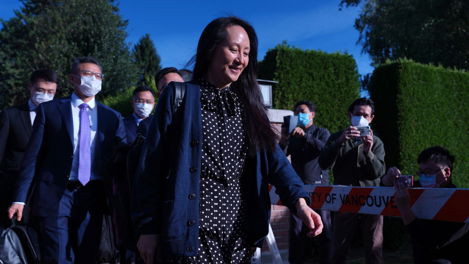Meng Wanzhou, chief financial officer of Huawei Technologies Co., center, exits her home in Vancouver, British Columbia, Canada, on Friday, Sept. 24, 2021