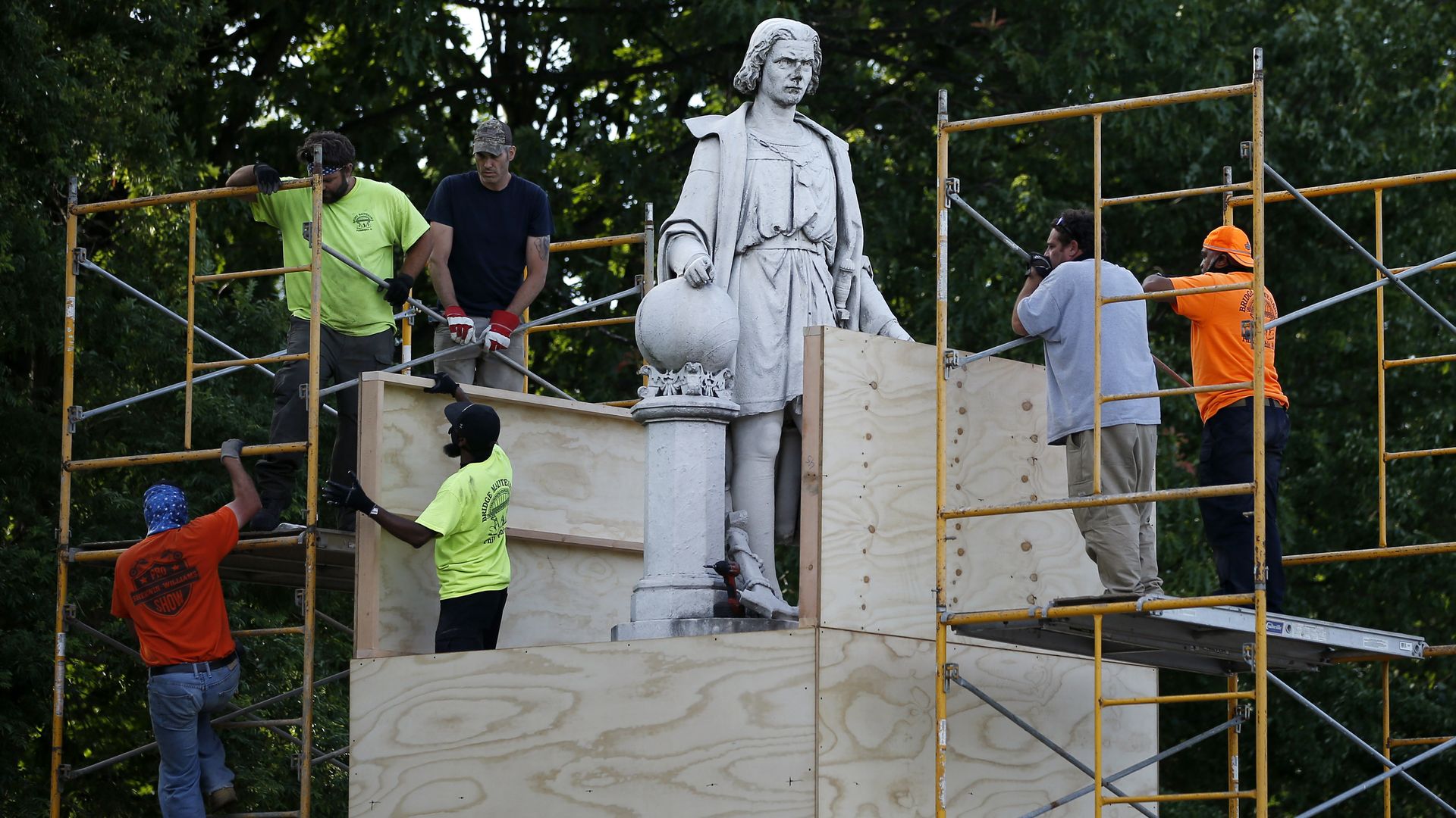 City workers cover the statue of Christopher Columbus at Marconi Plaza. 