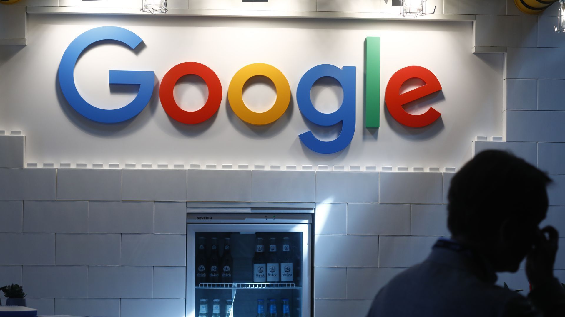 Google logo on wall over a soft-drink fridge