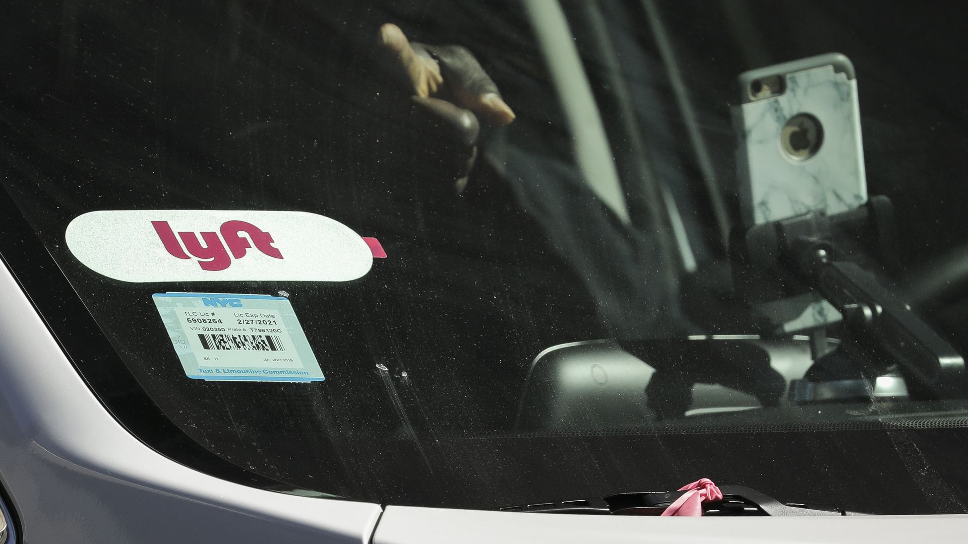 A car with the Lyft logo in the window