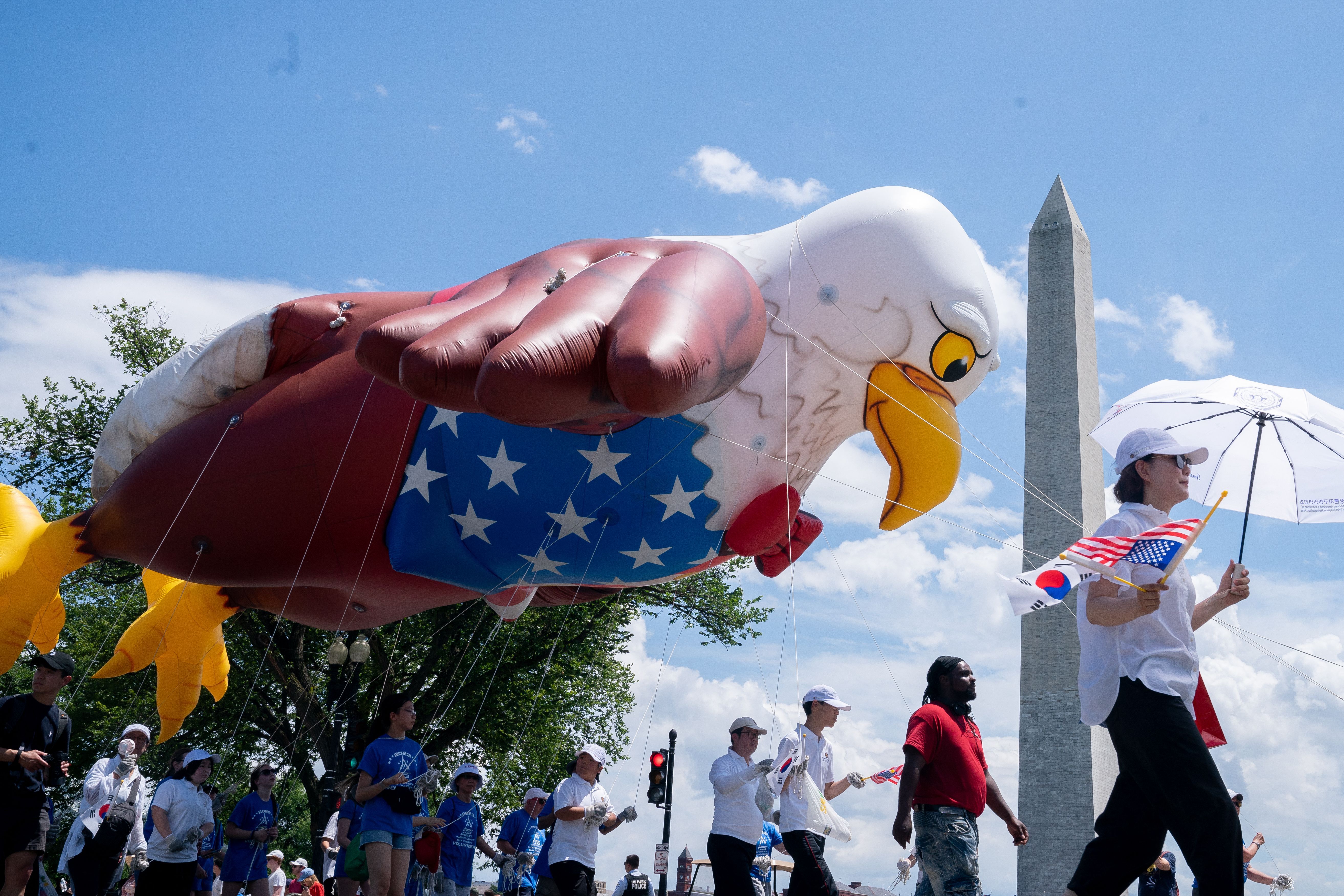 The Washington Monument is seen as participants march during the National Independence Day Parade in Washington, DC, on July 4, 2023.