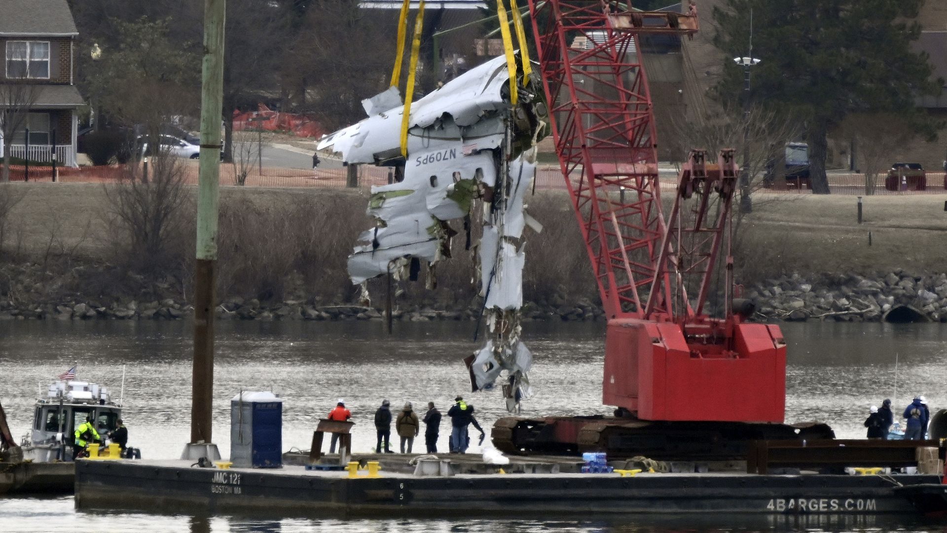 A recovery crane pulls up a portion of the fuselage of a regional jet airliner that collided with a military helicopter on Wednesday night on the Potomac River at Reagan National Airport in Arlington, VA on February 3, 2025. (Photo by John McDonnell/ for The Washington Post via Getty Images)