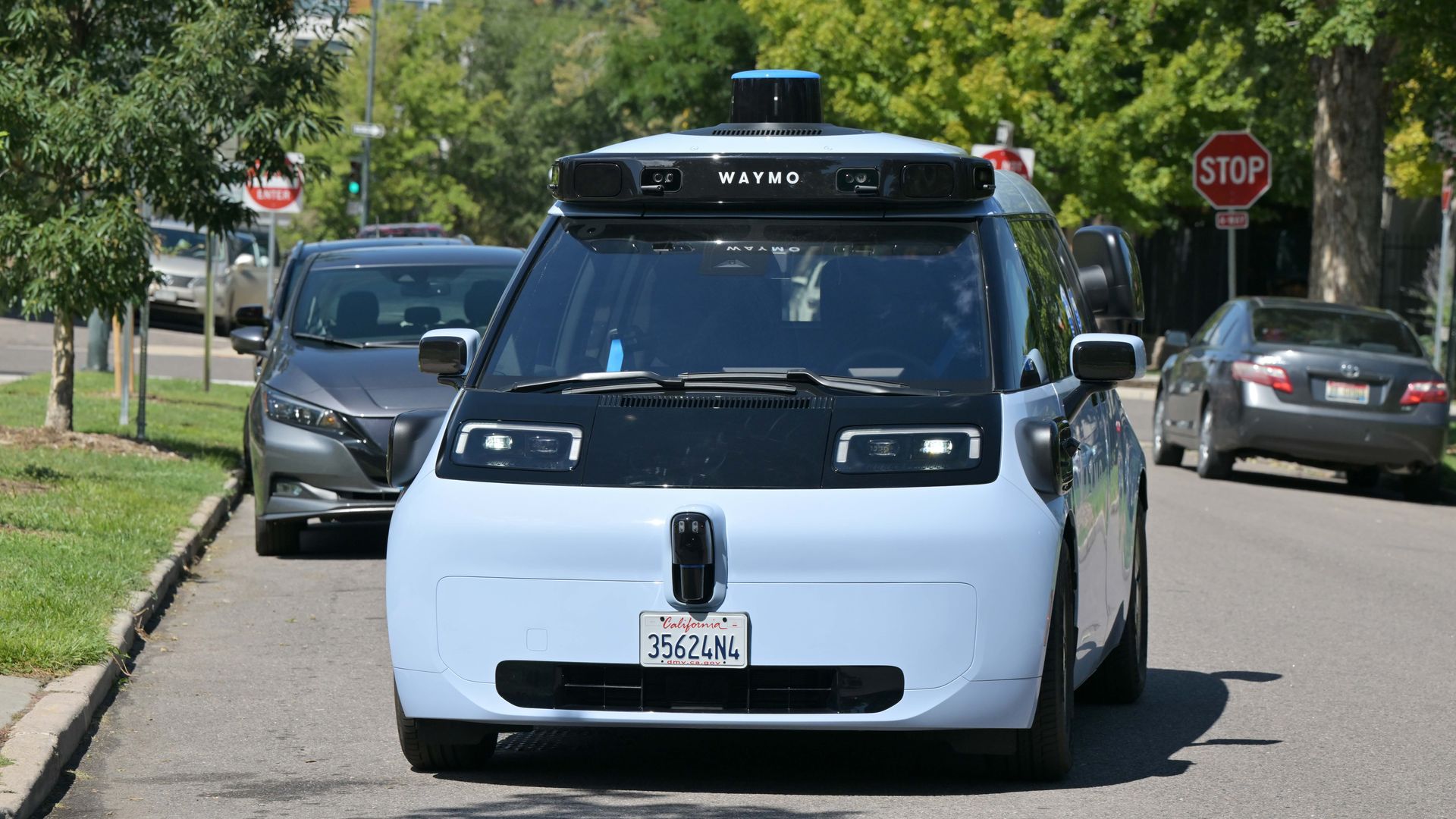 A photo of a blue-colored car with lots of cameras traveling down a Denver street.