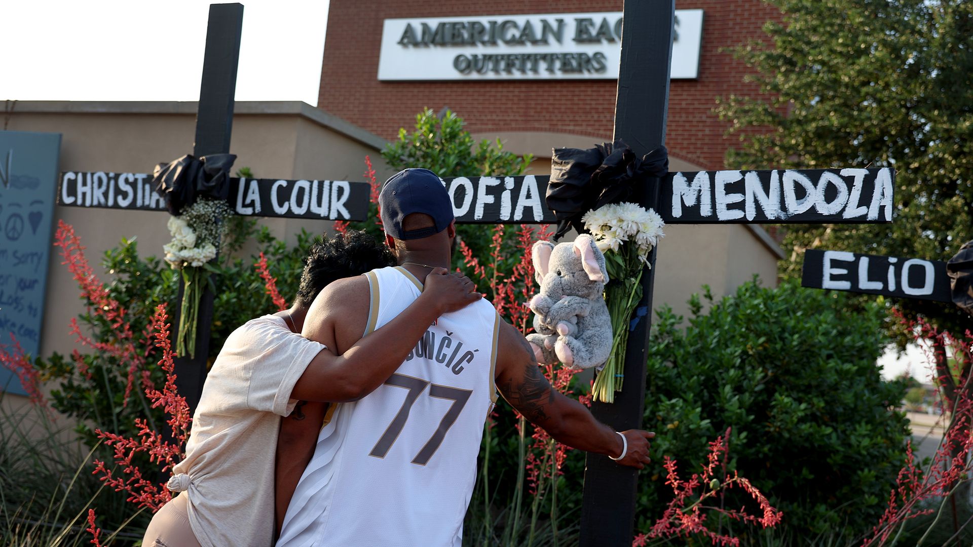 Robert Jackson and his mother Cheryl Jackson hug as they visit a memorial near the scene of a mass shooting at the Allen Premium Outlets mall on May 8, 2023 in Allen, Texas.