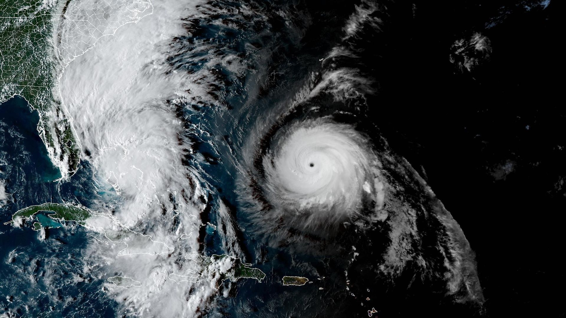 Satellite image showing two tropical storms in the Caribbean on 28 Sep 2025; one near Cuba and Florida, the other east of Puerto Rico with a well-defined eye, surrounded by swirling clouds.