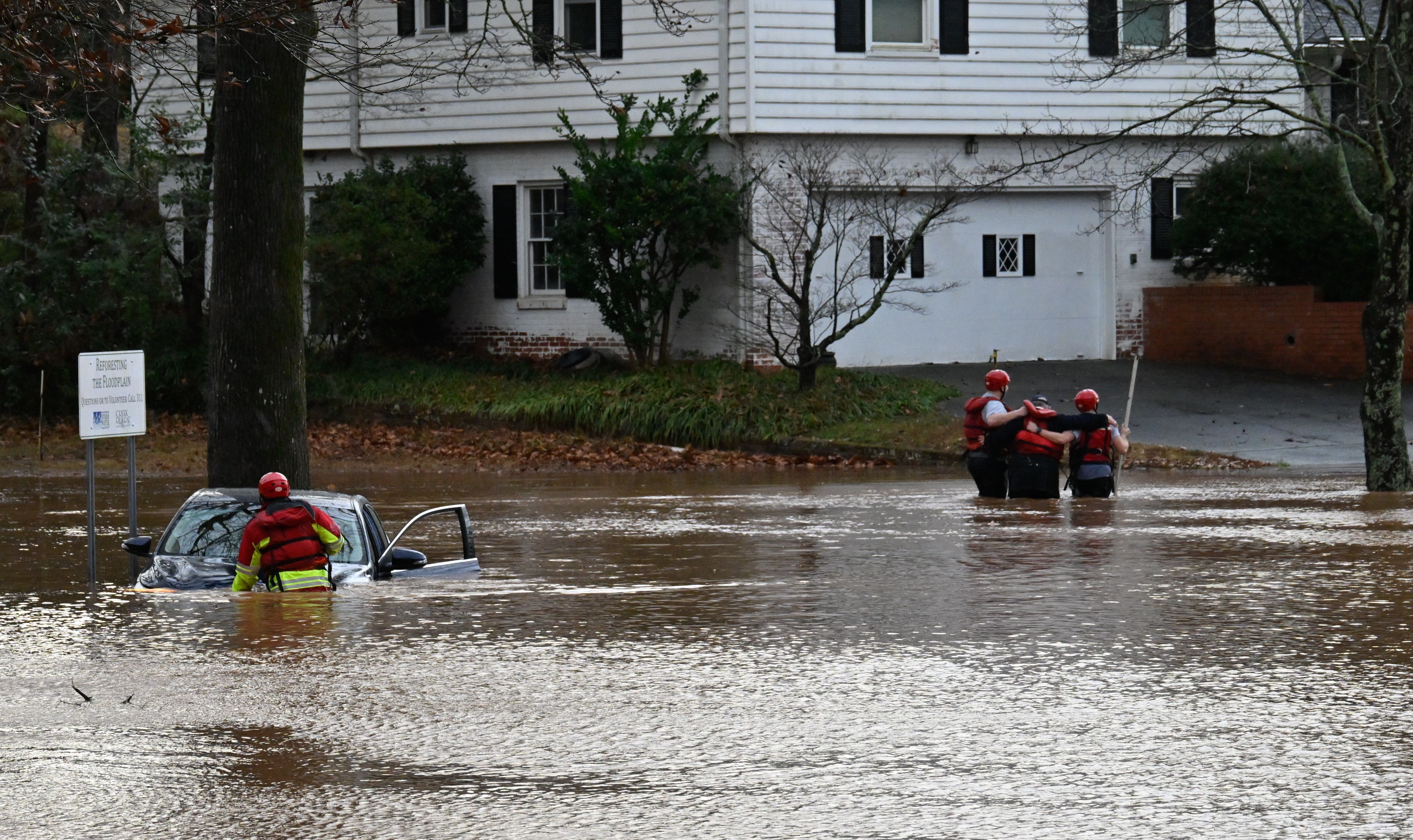 Firefighters rescue a man from a car stuck in a flooded area of in Charlotte, North Carolina, as storms move through the U.S. Southeast and the Carolinas, producing flooding, powerful winds and tornadoes.