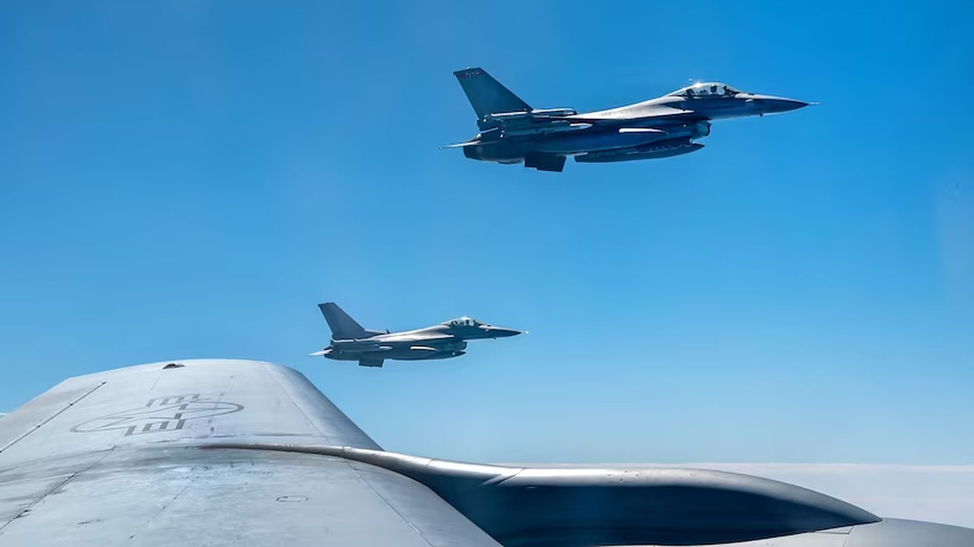U.S. military planes flying in blue sky at an undisclosed location.
