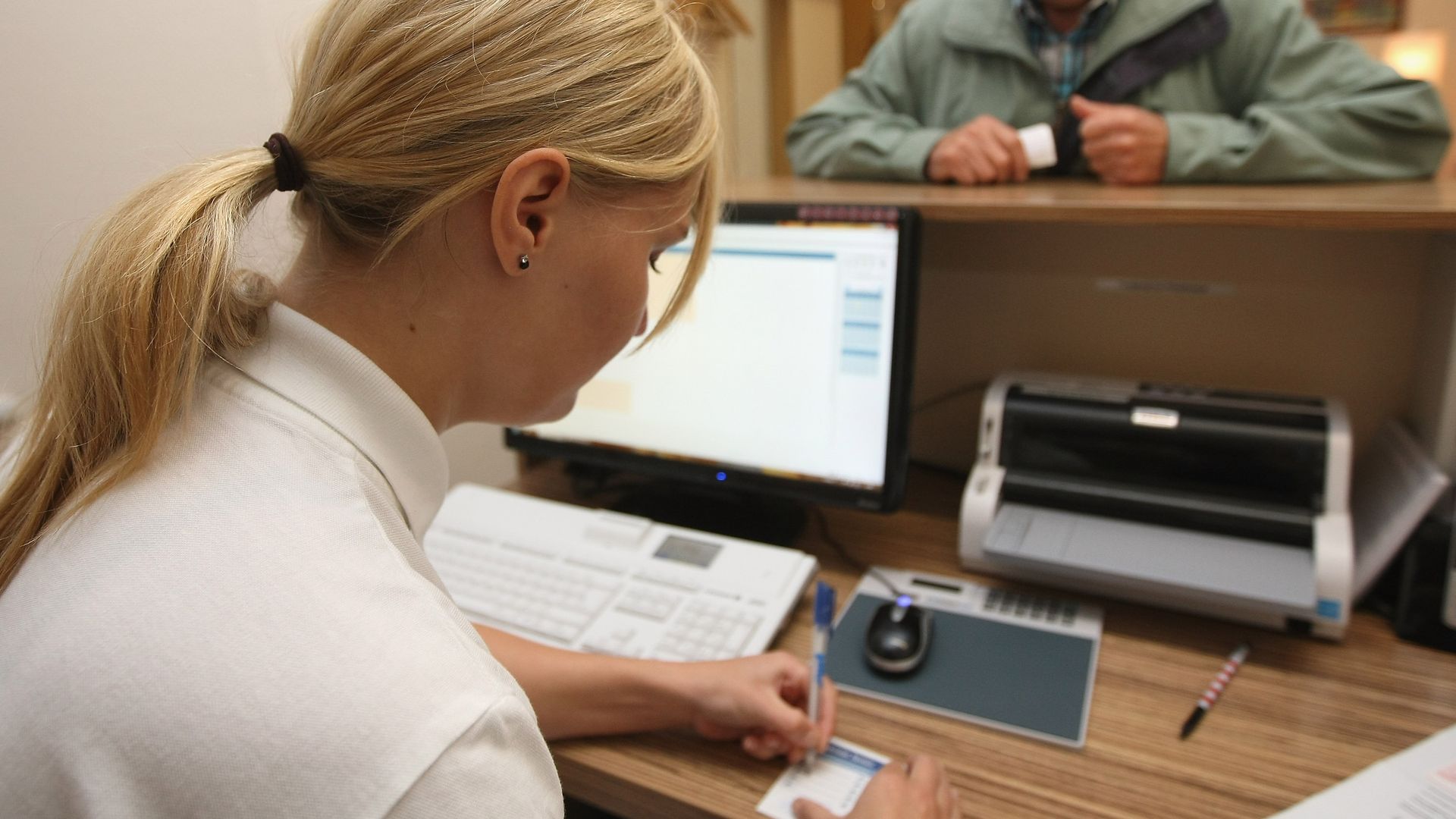 A nurse writes out an appointment date for a patient. 