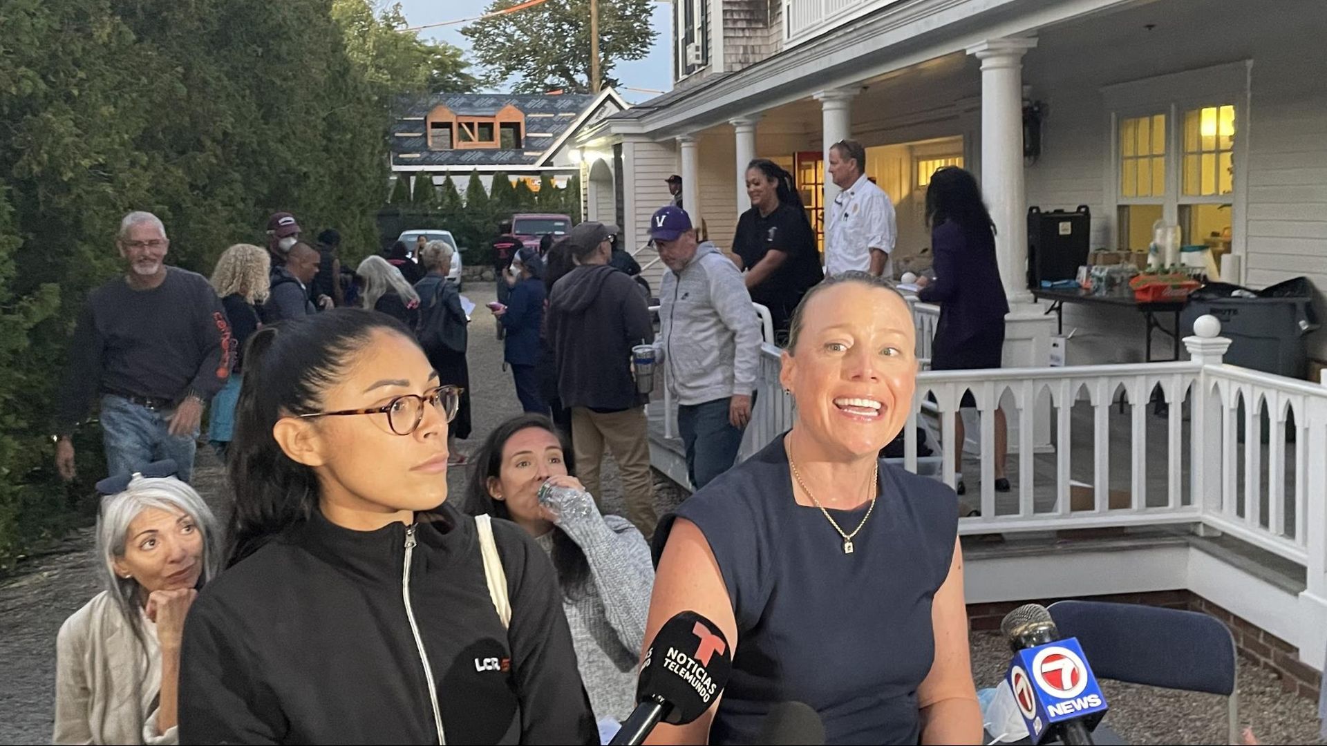 Two women speaking to news reporters.