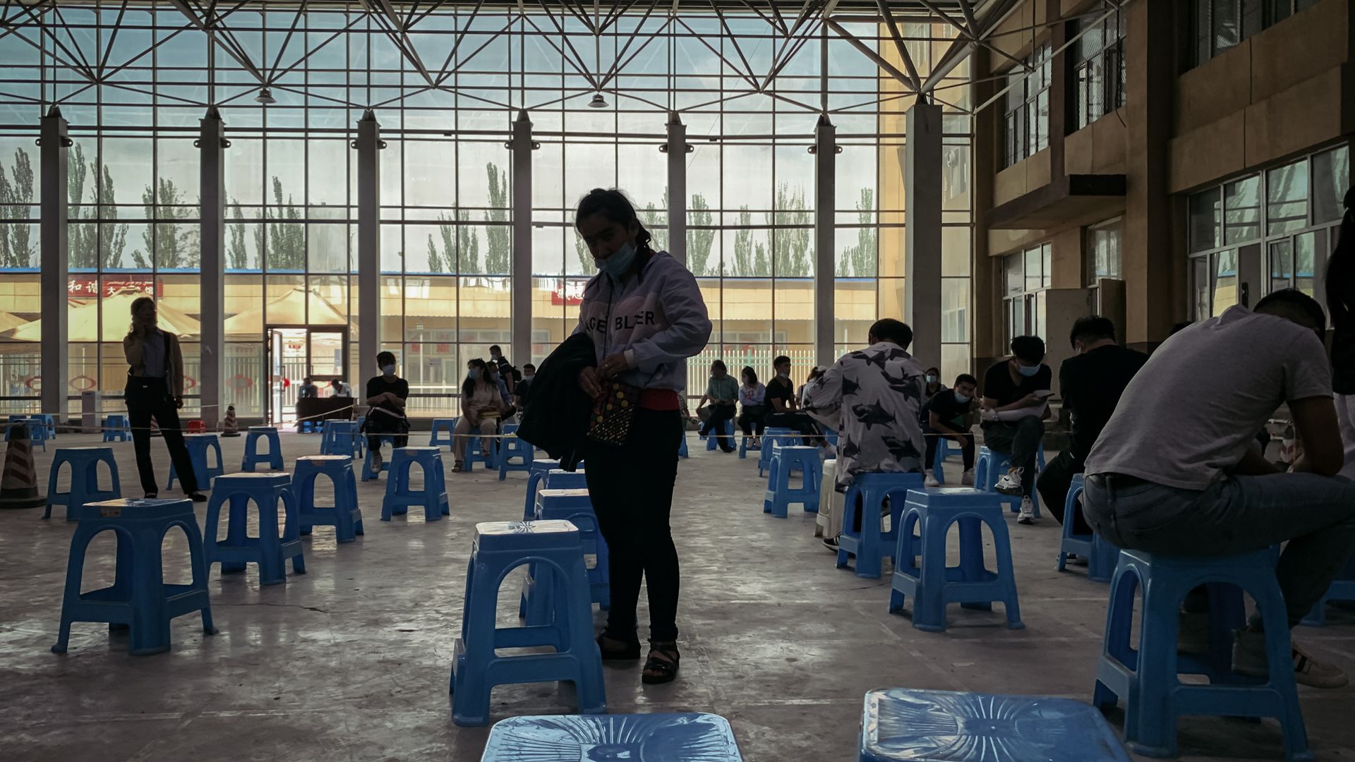 Arriving passengers are waiting to be registered and tested at a temporary space on June 30, 2020 in Kashgar, China