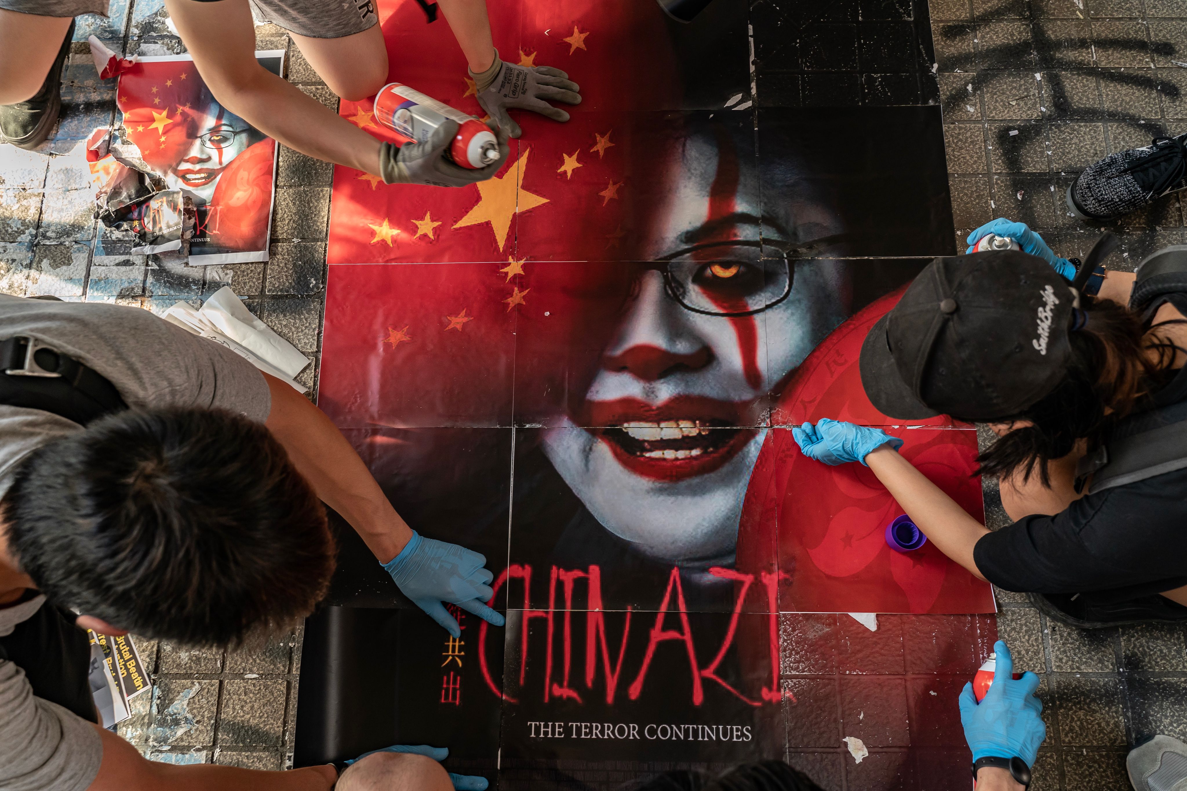 Protestors painting a poster of Hong Kong's leader