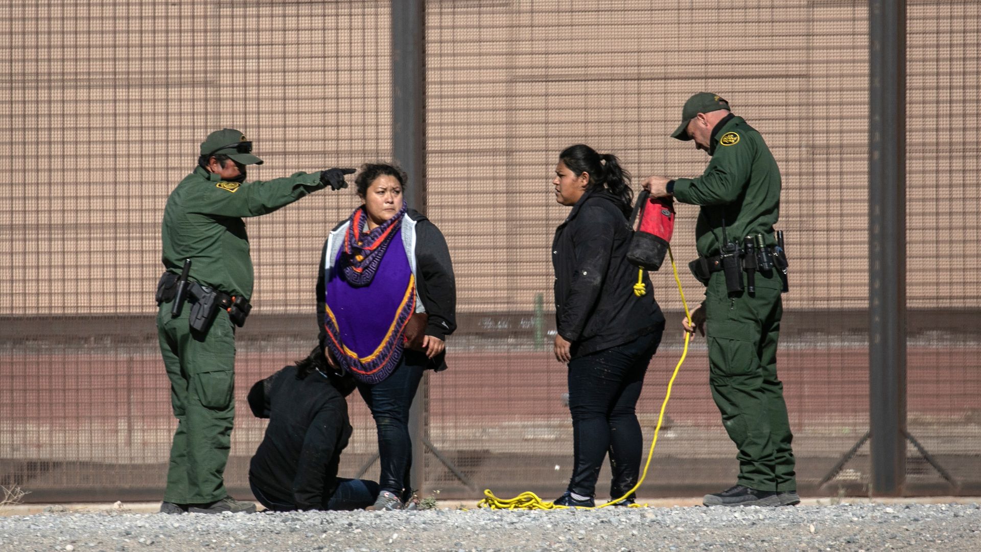 U.S. Border Patrol agents detain undocumented immigrants next to the U.S.-Mexico border fence after the women crossed the Rio Grande into El Paso on March 17
