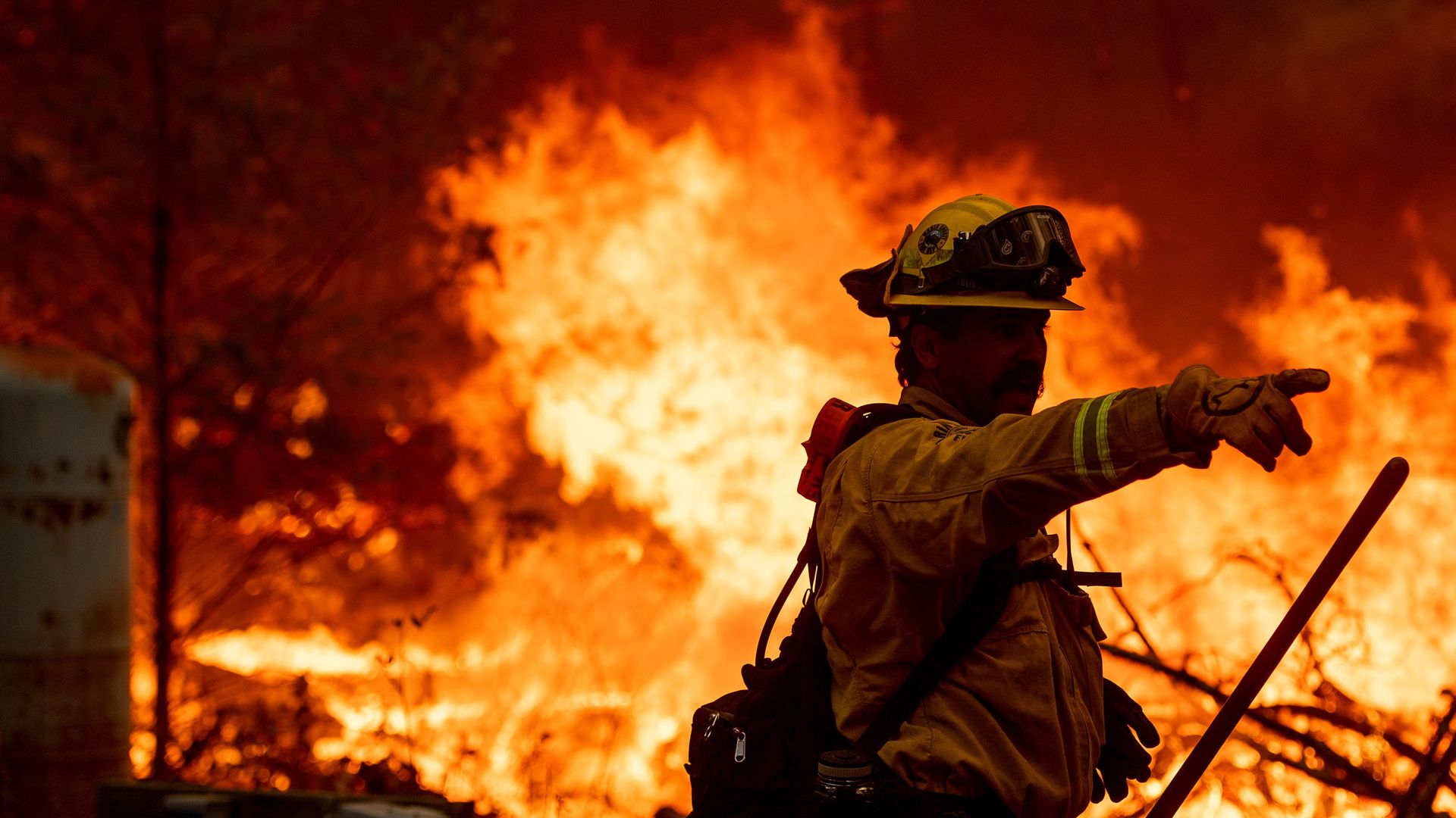 A firefighter motions towards other firefighters as they work the scene during the Glass fire in St. Helena, California on September 27