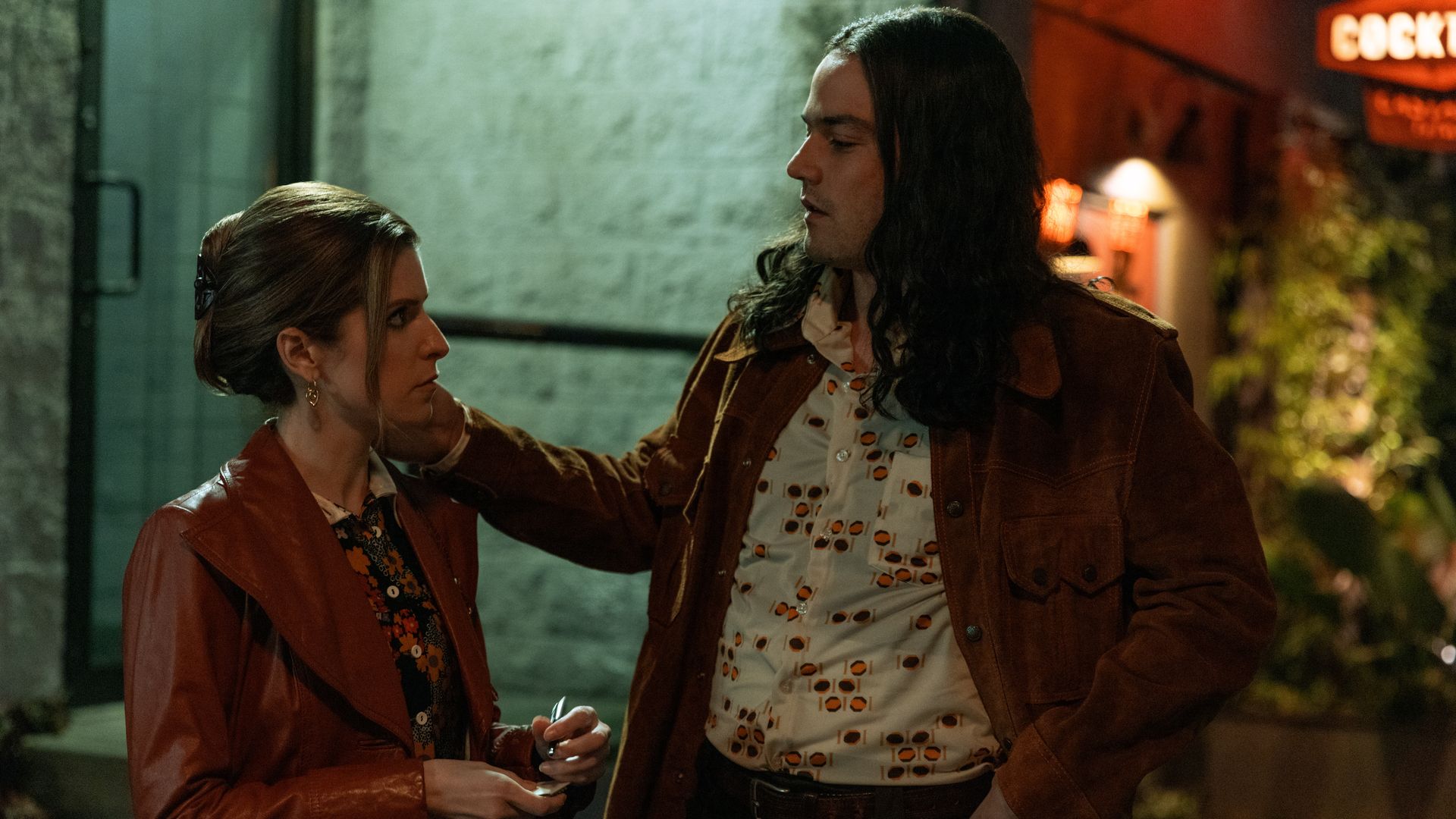 A man touches a woman's neck. 