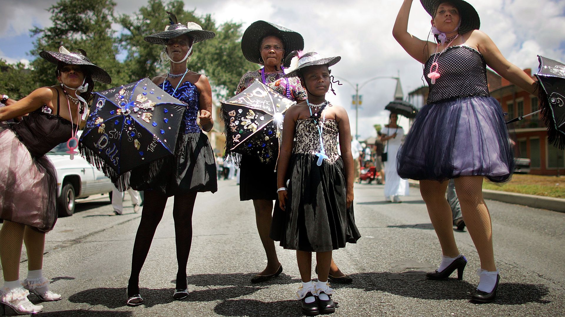 Four women and a girl pause during a second-line.
