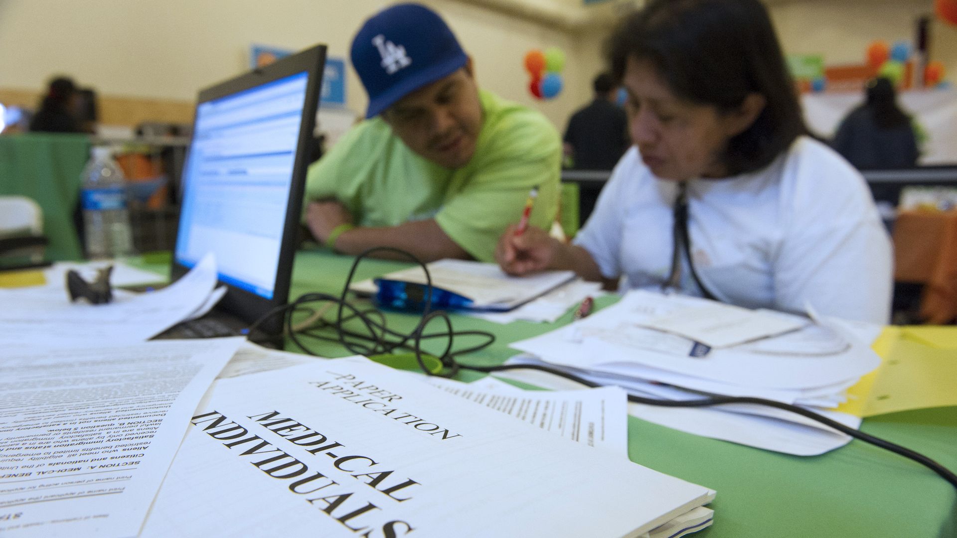 A Latino couple fills out forms for medical insurance.