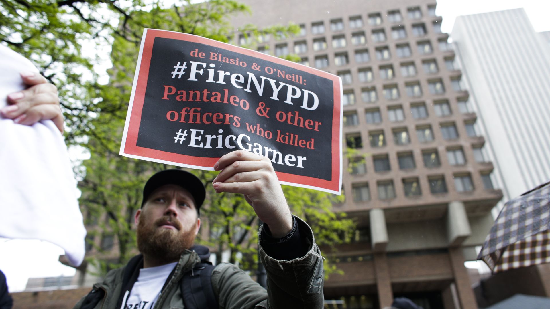 Protestor holding a sign saying officers involved in Eric Garner's death should be fired