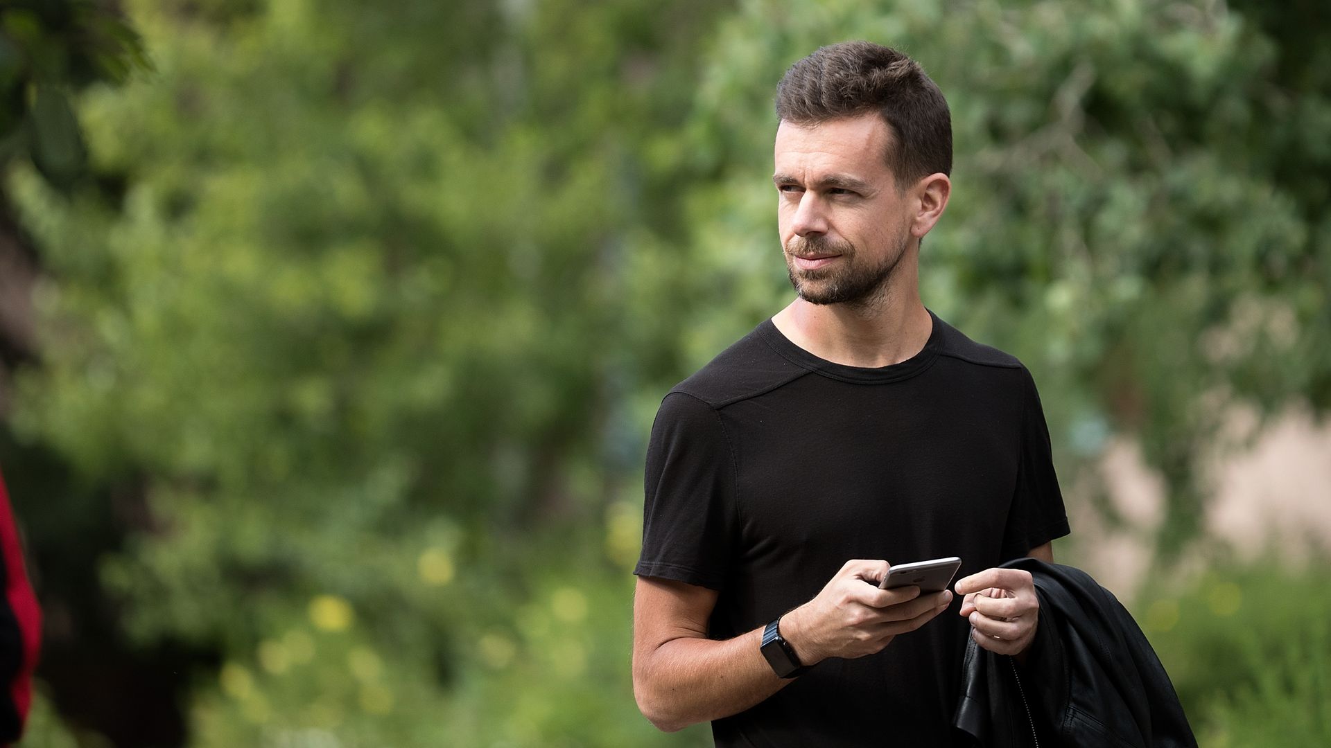 Twitter CEO Jack Dorsey wears a black t-shirt and stands outside