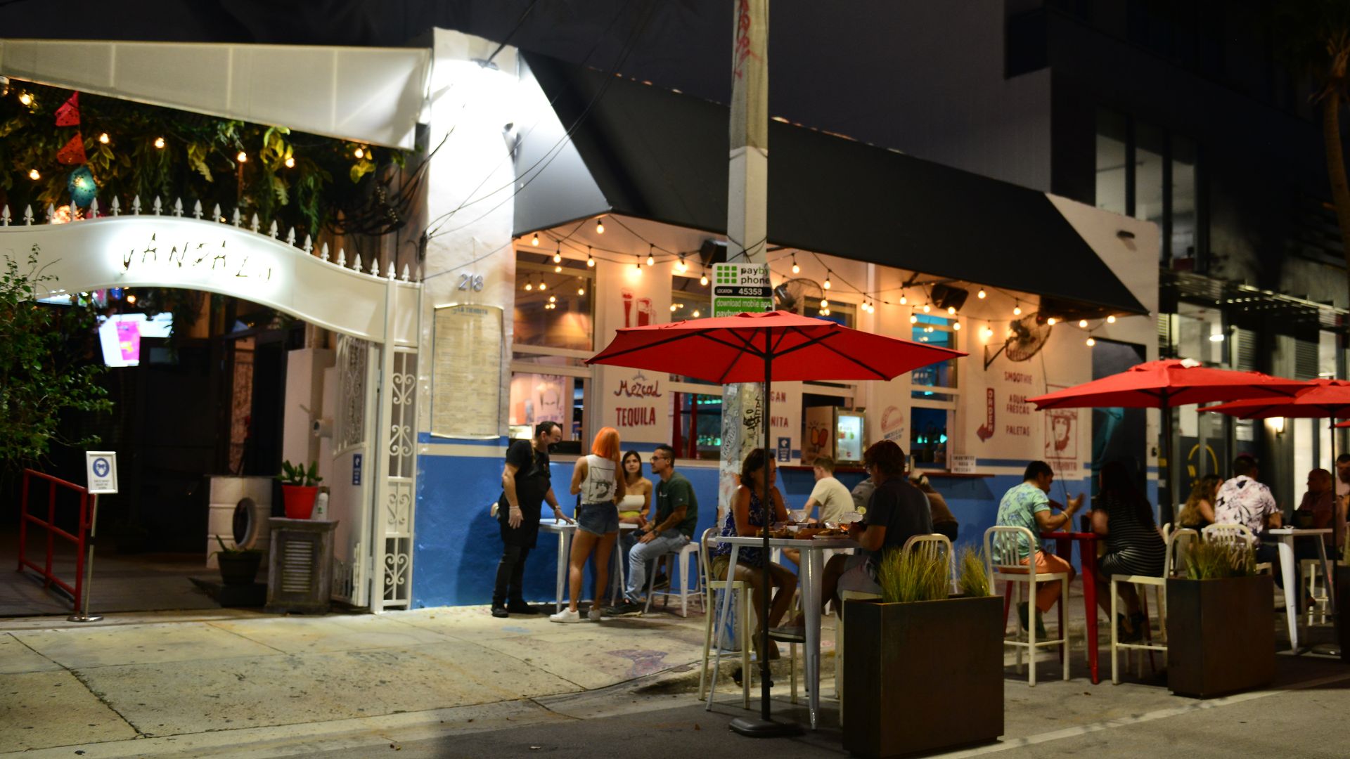 People dining outside a restaurant in Miami in July.