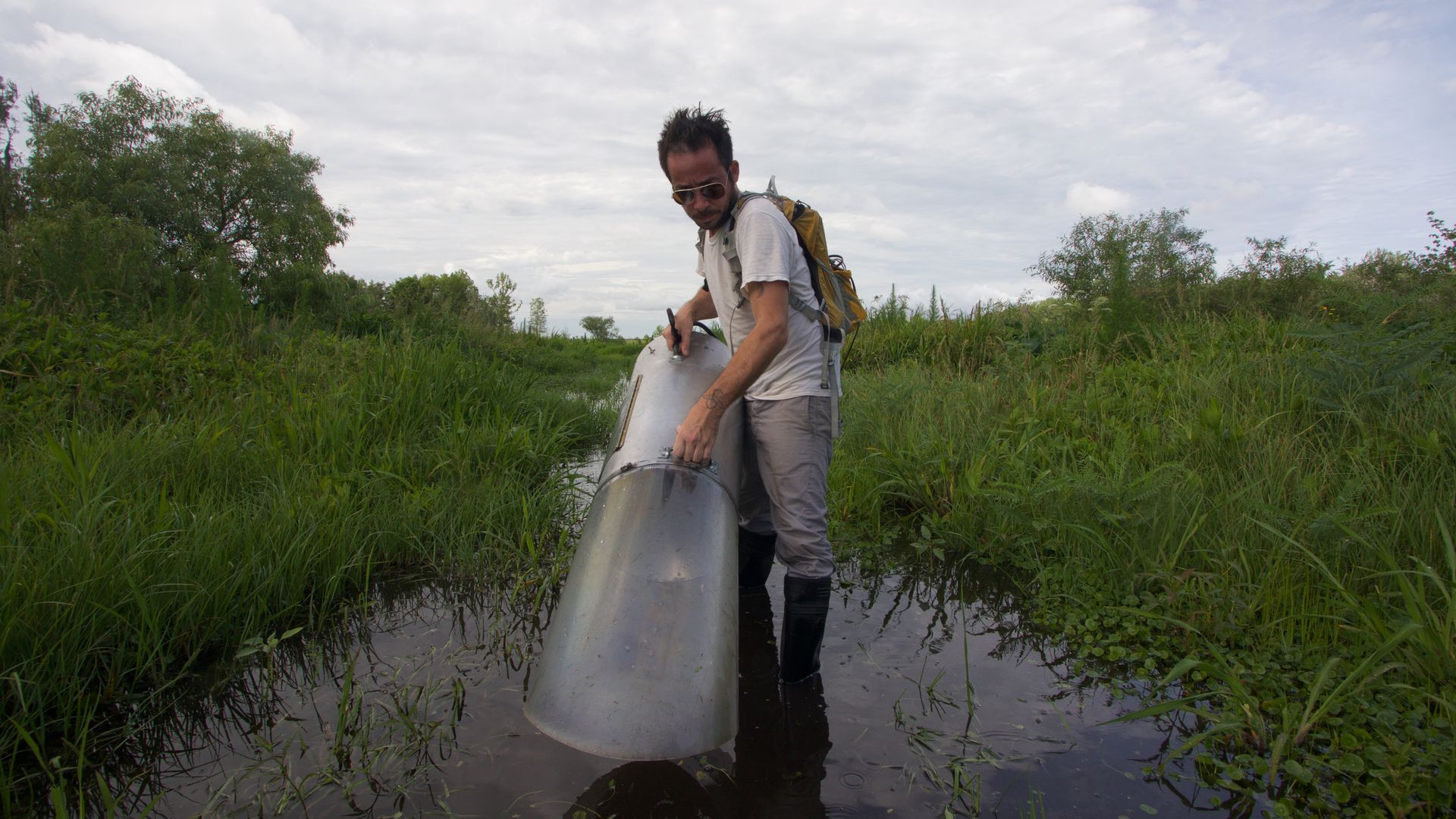 Mosquito biologist Lawrence Reeves uses an aspirator machine to collect mosquitoes.