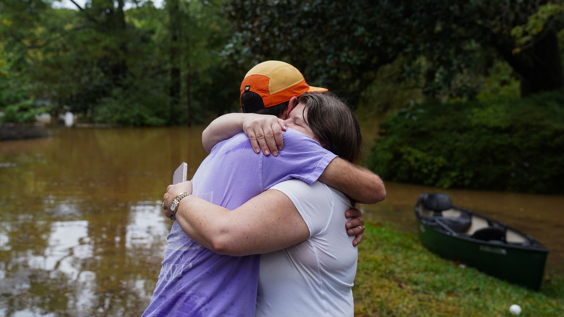 Dan Murphy hugs his colleague after bringing his canoe to rescue them from their flooded home as the streets were flooded near Peachtree Creek after Tropical Storm Helene brought in heavy rains to Atlanta