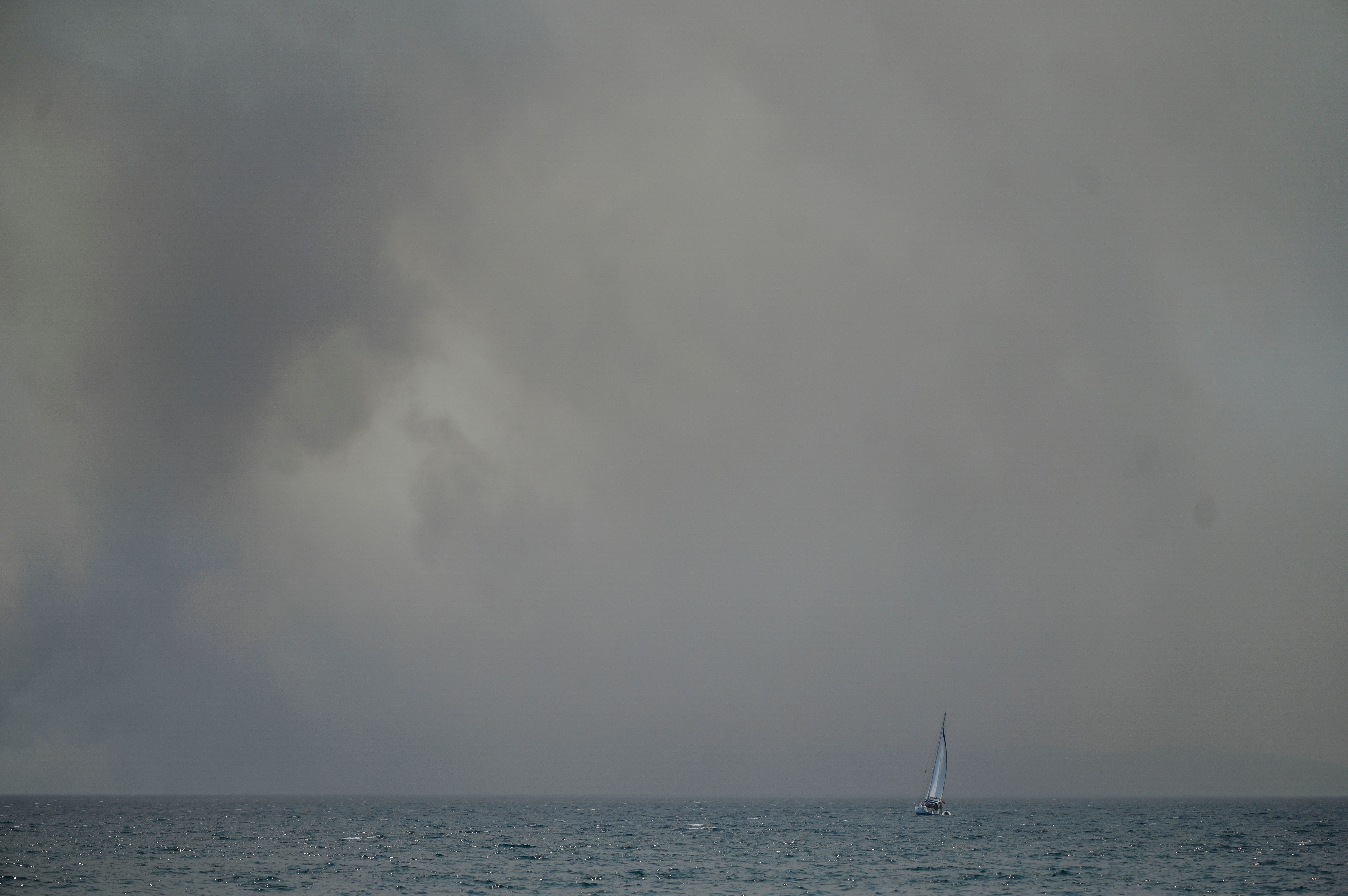  A ship sails near the coastal town of Saranda as heavy smoke billows from the Greek Island of Corfu on July 25, 2023. Authorities evacuated nearly 2,500 people from the Greek island of Corfu on July 24, 2023, as the heat-battered nation was "at war" with several wildfires. Tens of thousands of people have already fled blazes on the island of Rhodes, with many frightened tourists scrambling to get home on evacuation flights.
