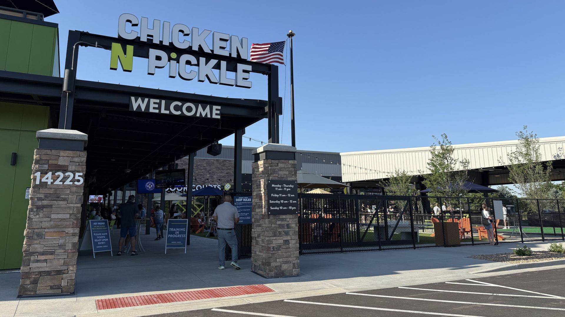 Outside a massive restaurant with the words CHICKEN N PICKLE WELCOME. 