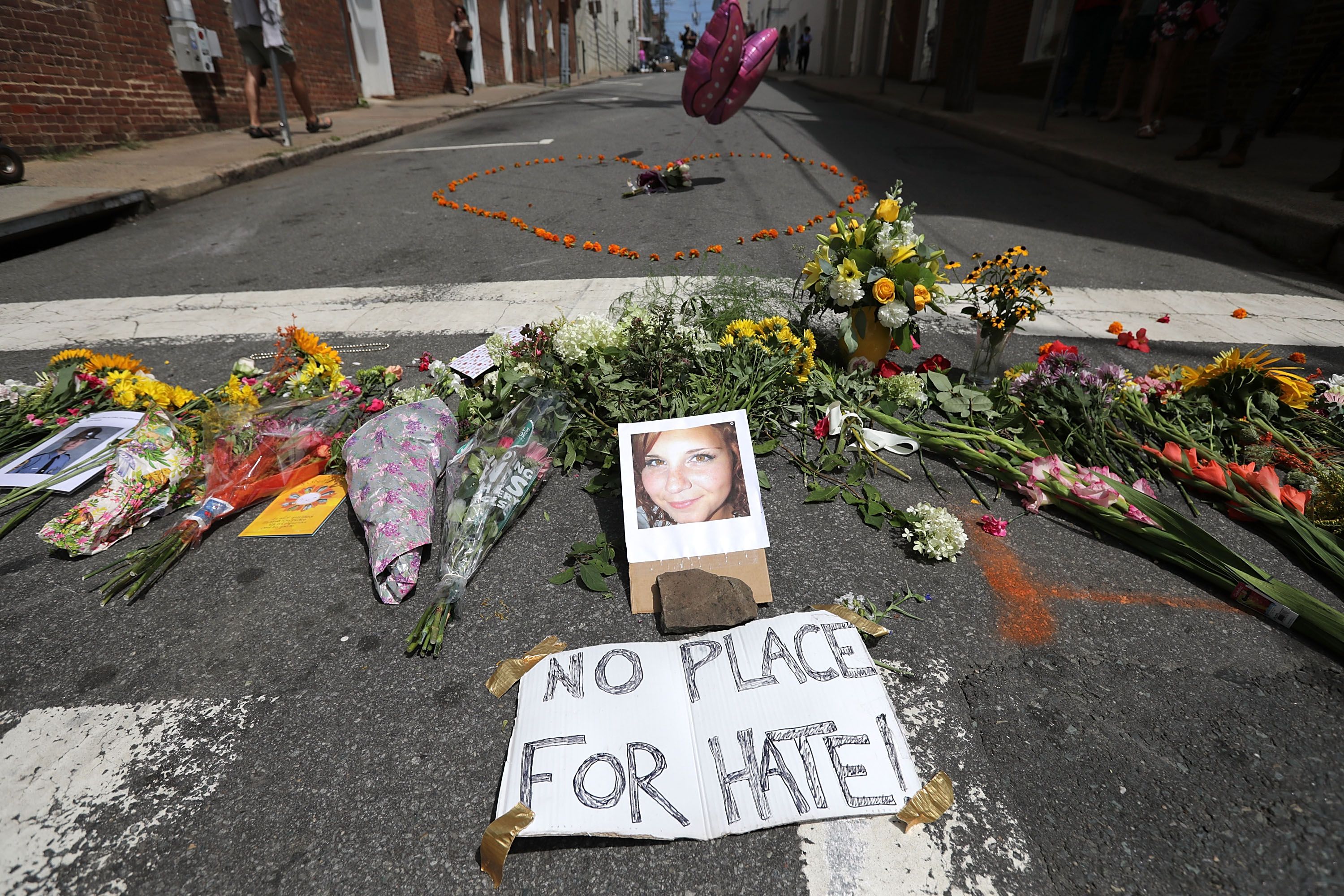Flowers surround a photo of 32-year-old Heather Heyer, who was killed when a car plowed into a crowd protesting white supremacist Unite the Right rally, August 13, 2017 in Charlottesville, Virginia. 