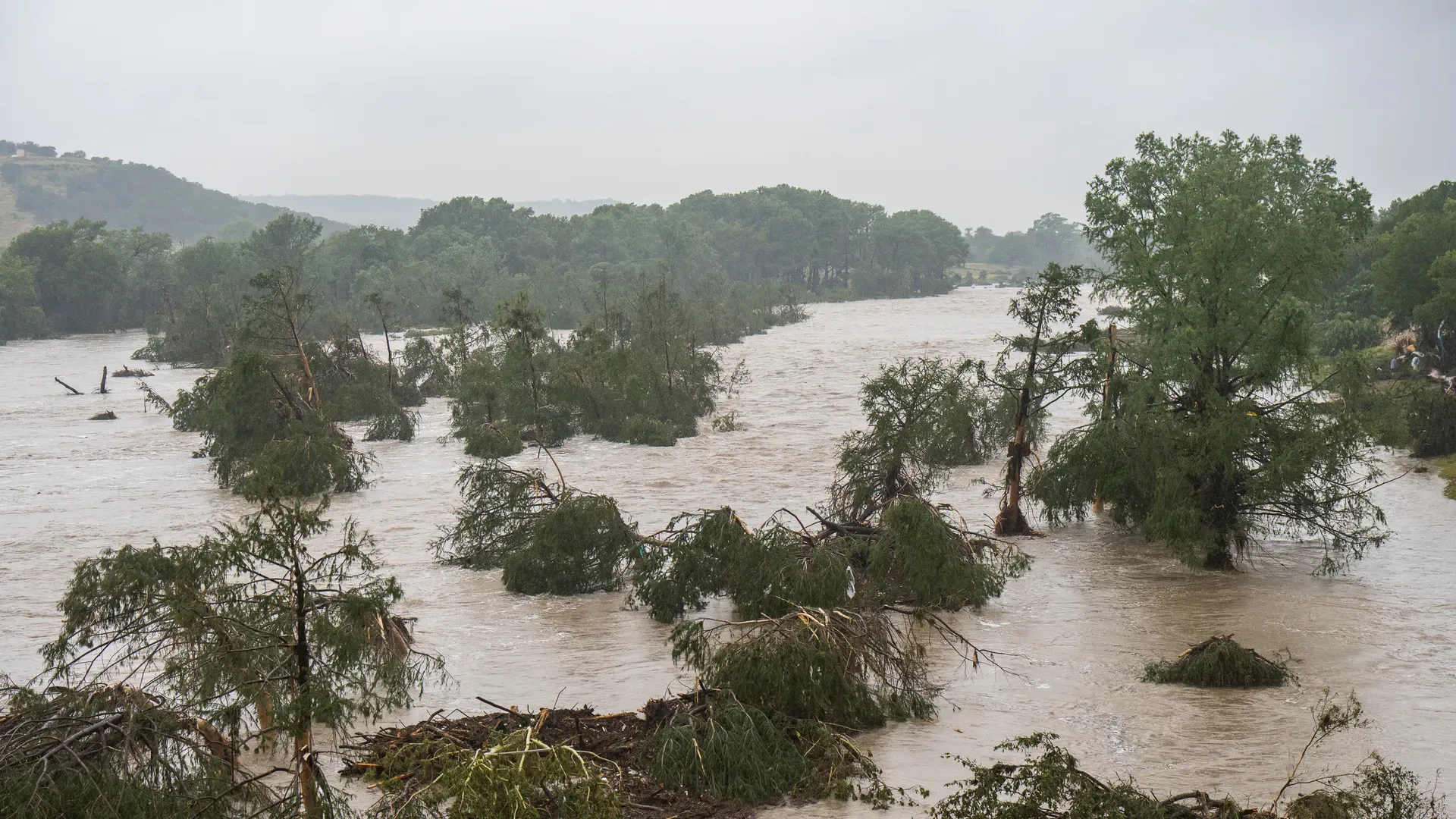 Trees emerge from flood waters along the Guadalupe River on Friday in Kerrville, Texas.