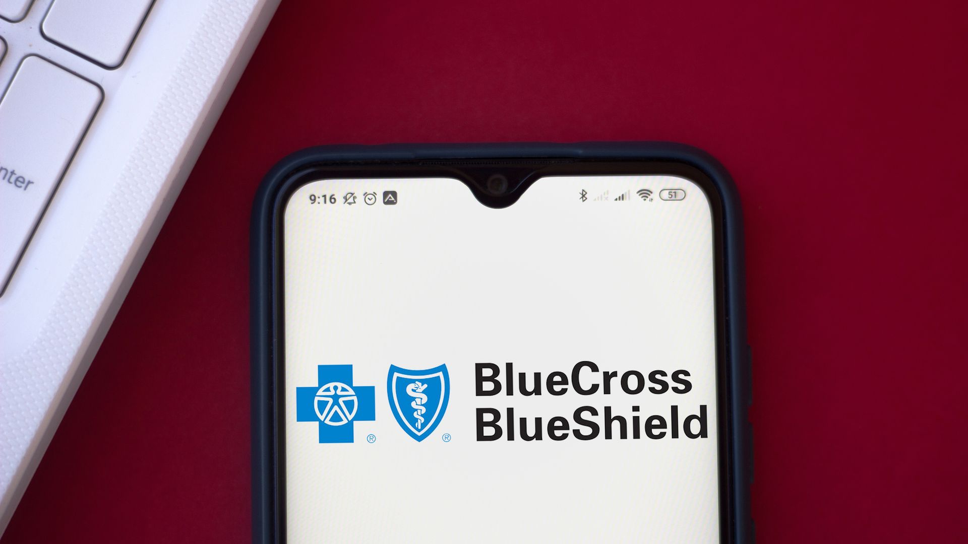 The blue and white Blue Cross Blue Shield logo on a cell phone.