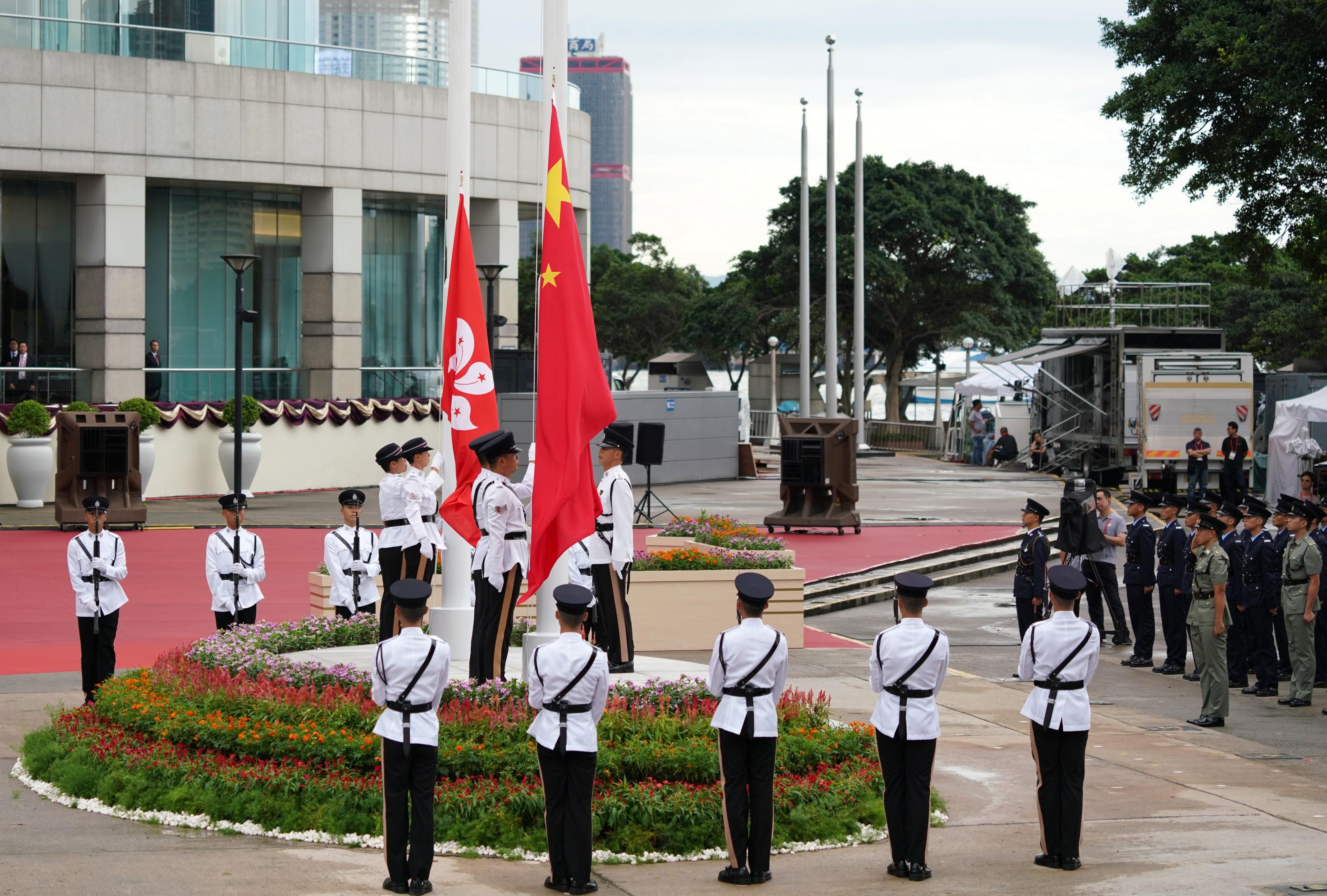 Police officers attend a flag raising ceremony to commemorate the 22nd Anniversary of the Establishment of the Hong Kong Special Administrative Region (SAR) at Golden Bauhinia Square.