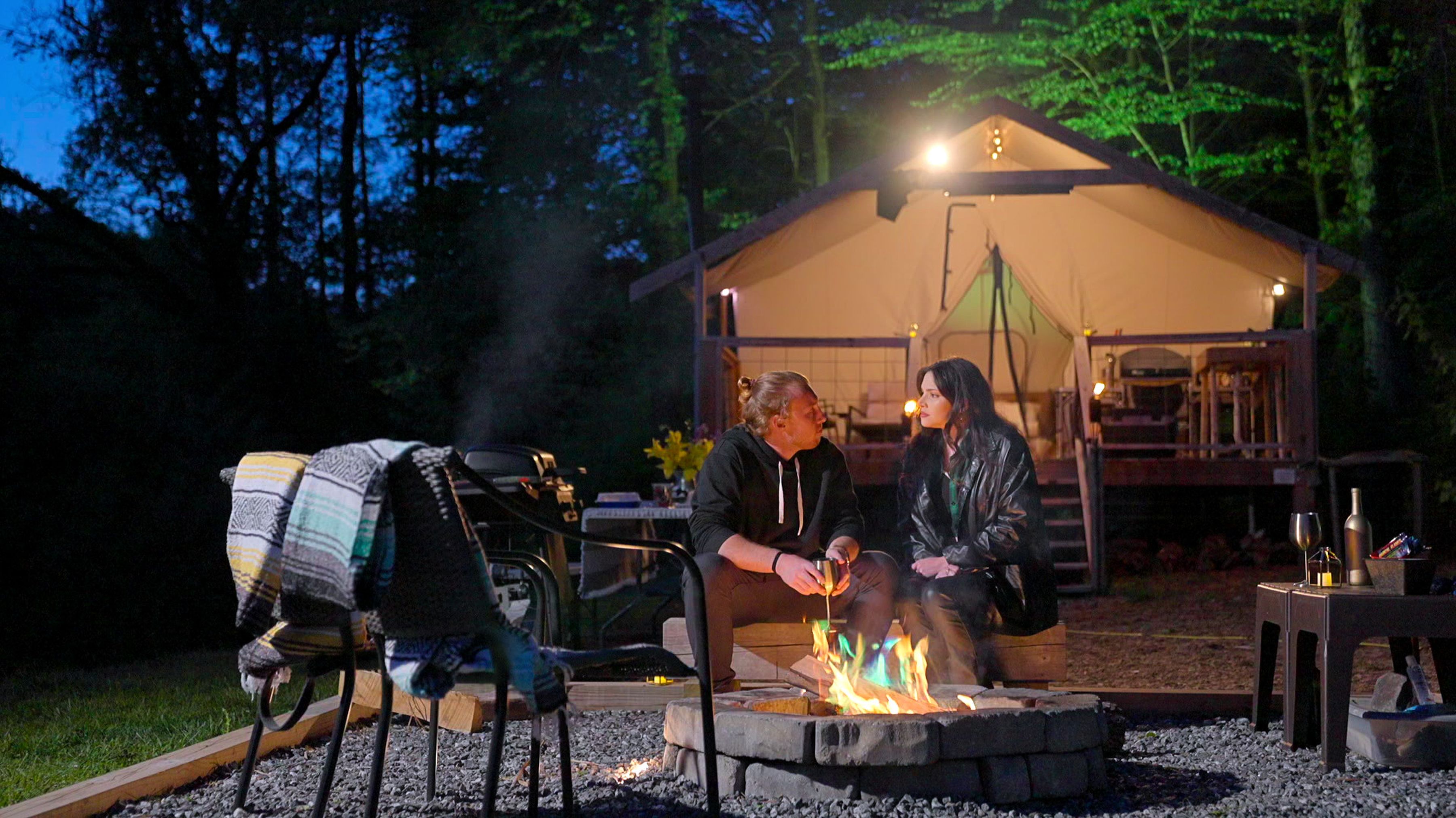 two people in front of a camp fire