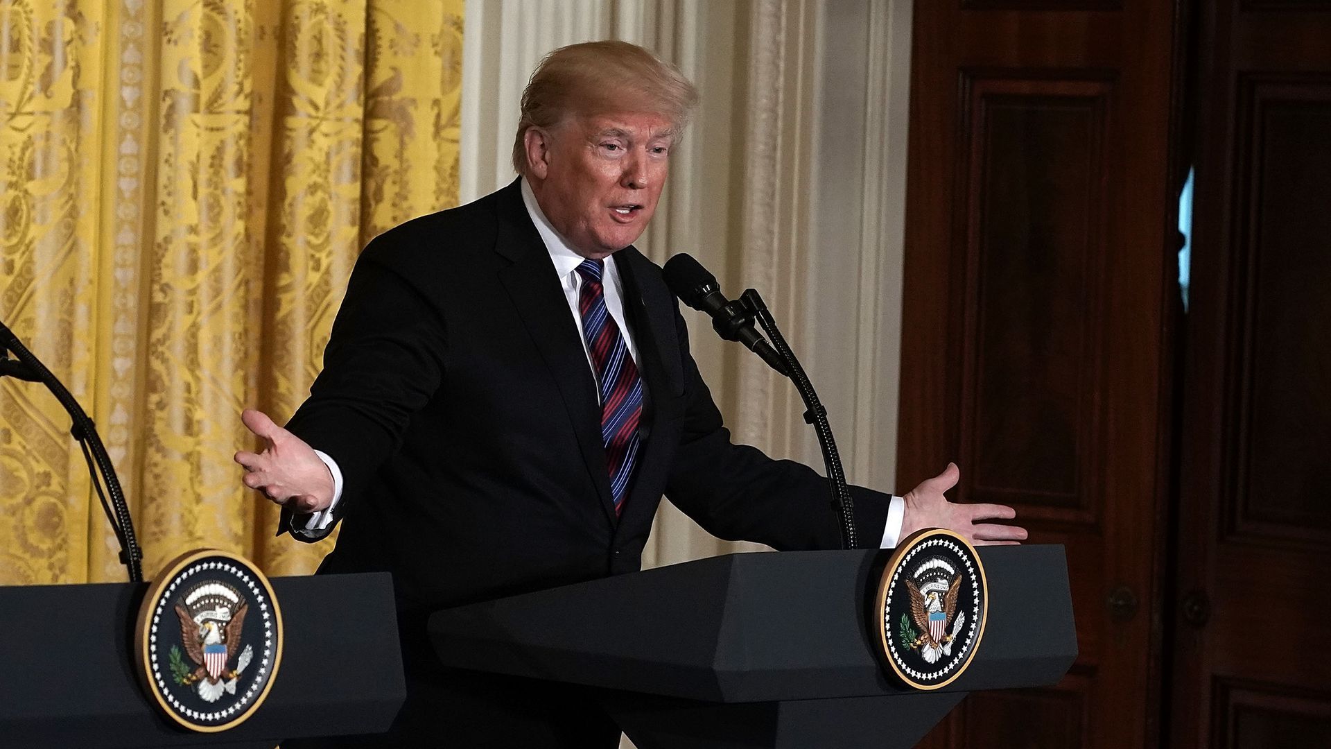 President Trump gestures while behind the podium at a press conference