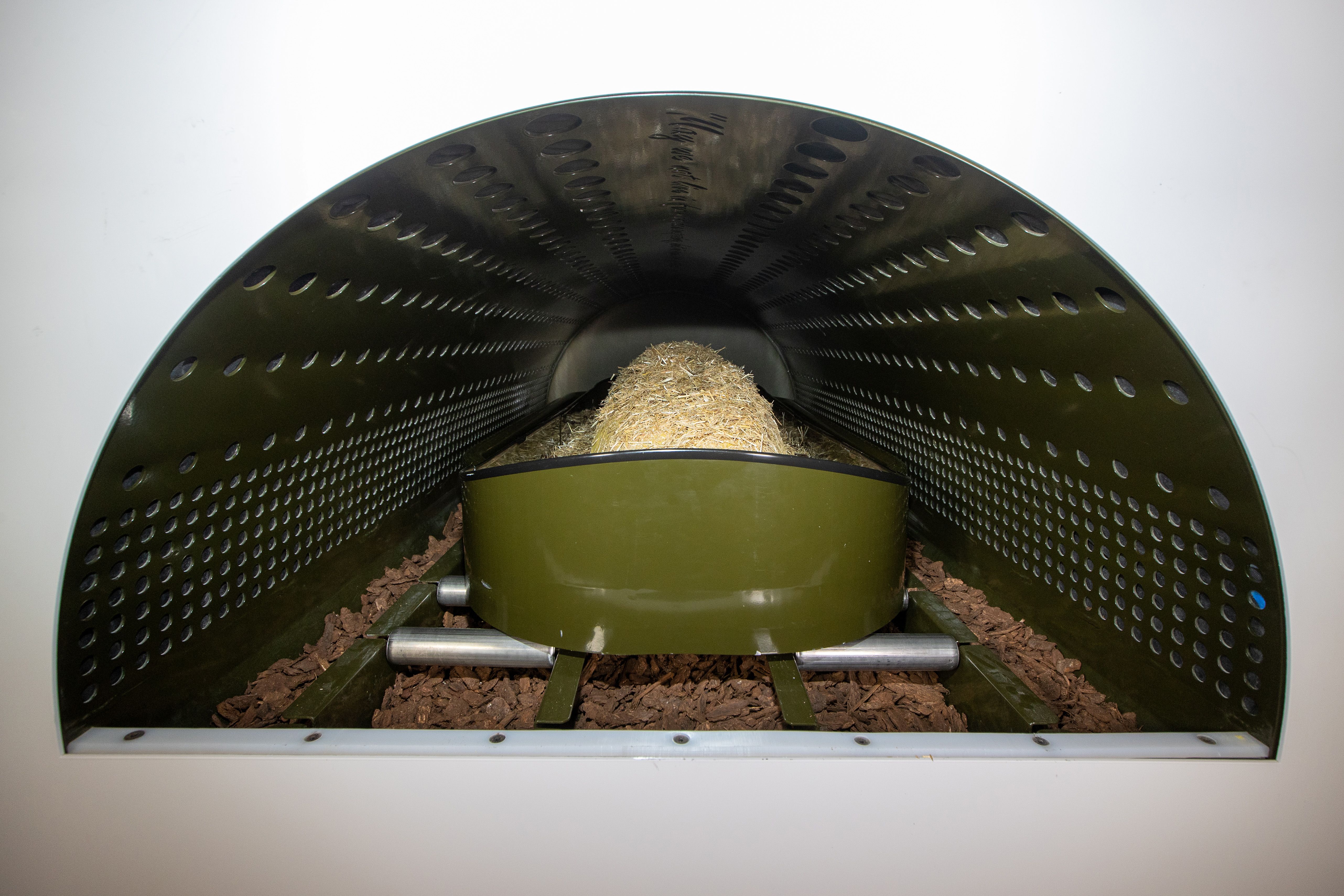 A shroud is covered in straw inside a long, thin capsule-like vessel that will be closed to allow the human composting process to begin. 