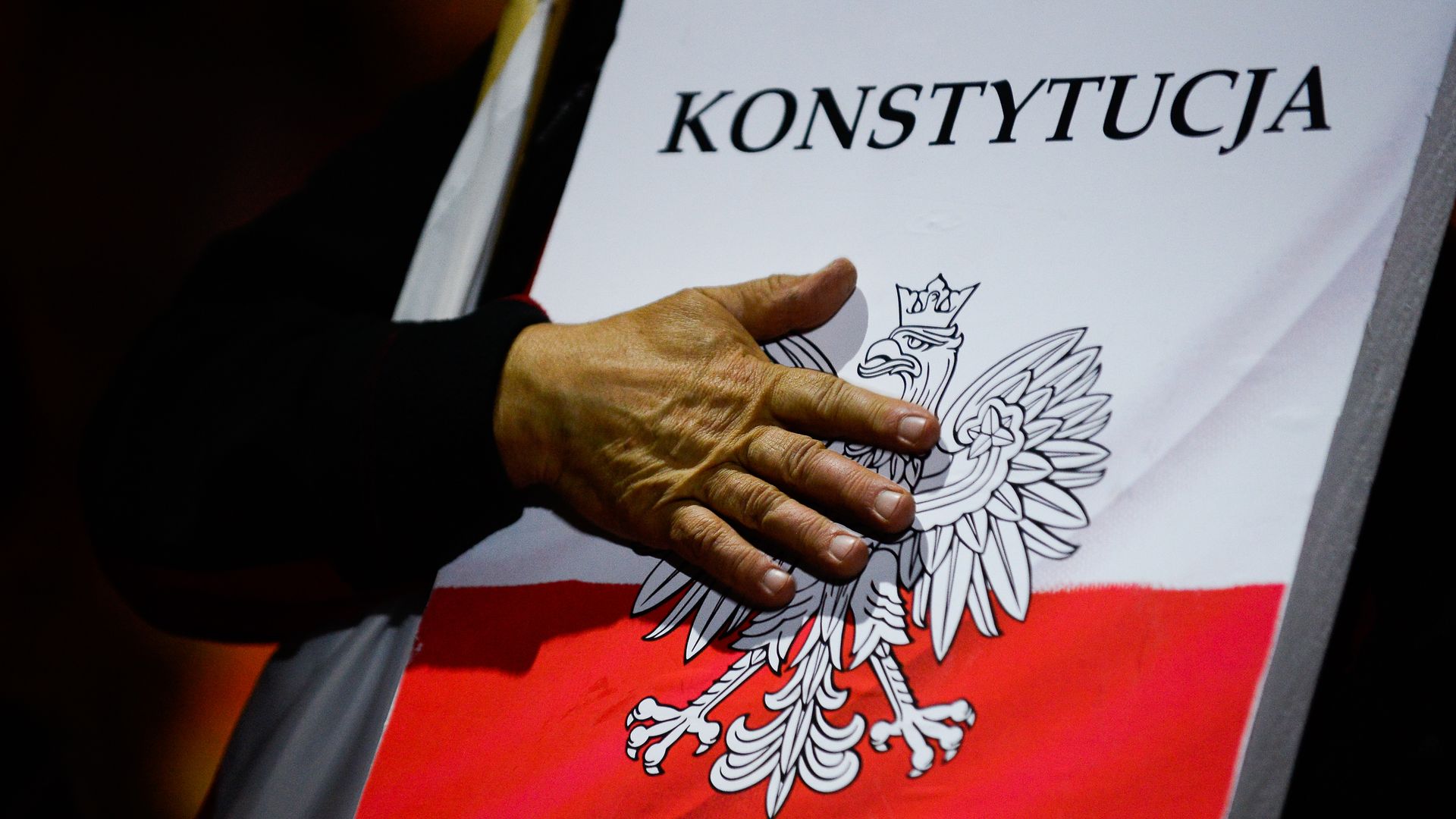 Protester with hand on Poland constitution