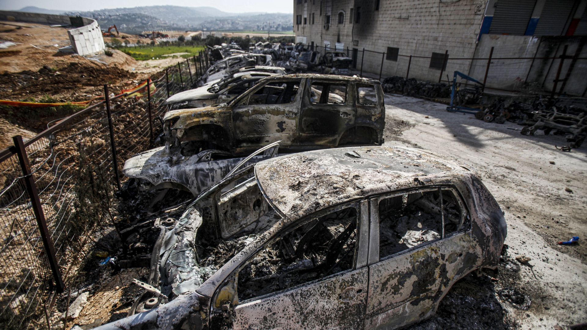 View of damaged building and scorched cars in the town of Hawara, near the West Bank city of Nablus.