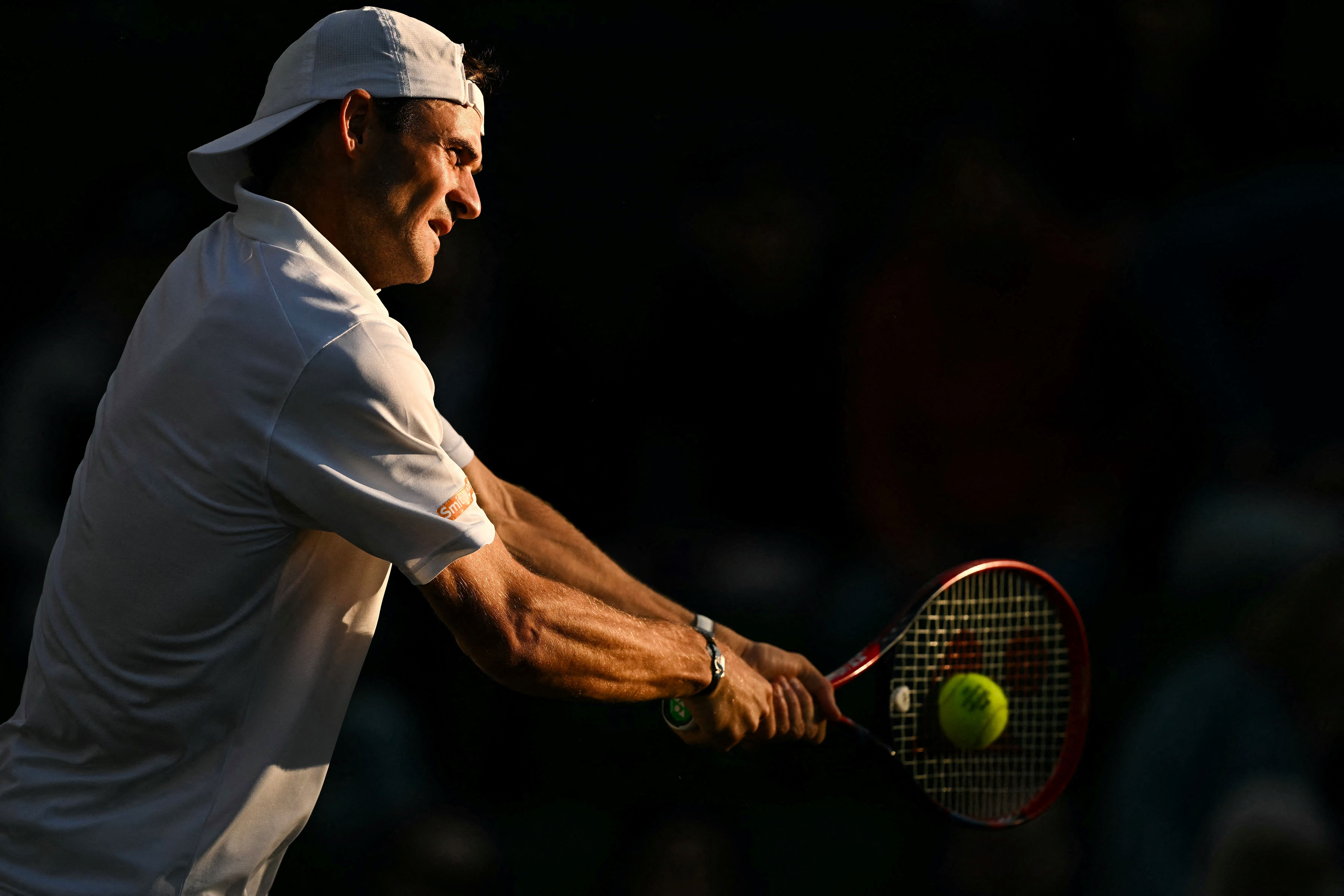 Tommy Paul hits a tennis ball. 