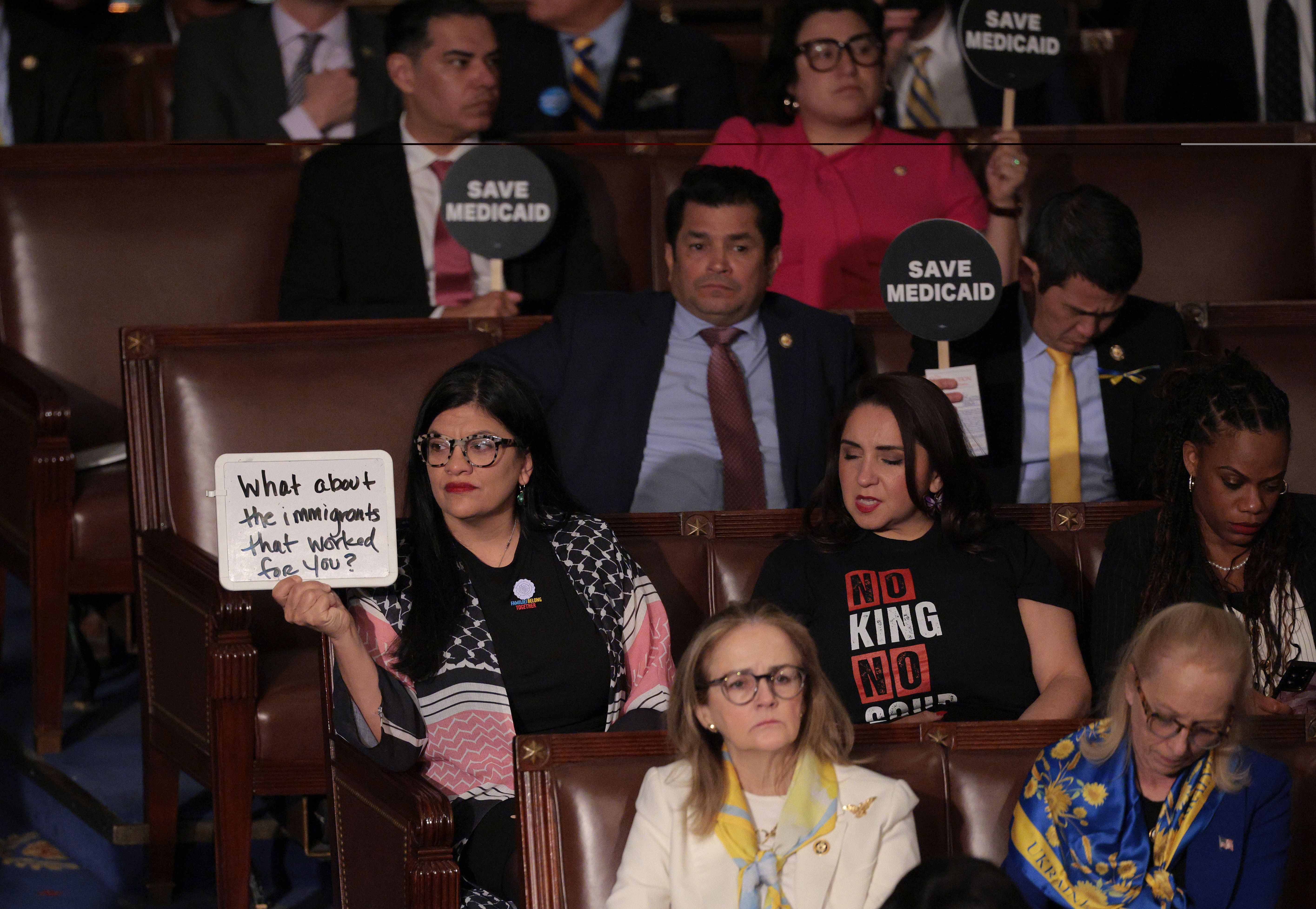 Democrats hold protest signs as U.S. President Donald Trump address a joint session of Congress at the U.S. Capitol on March 04, 2025 in Washington, DC. 