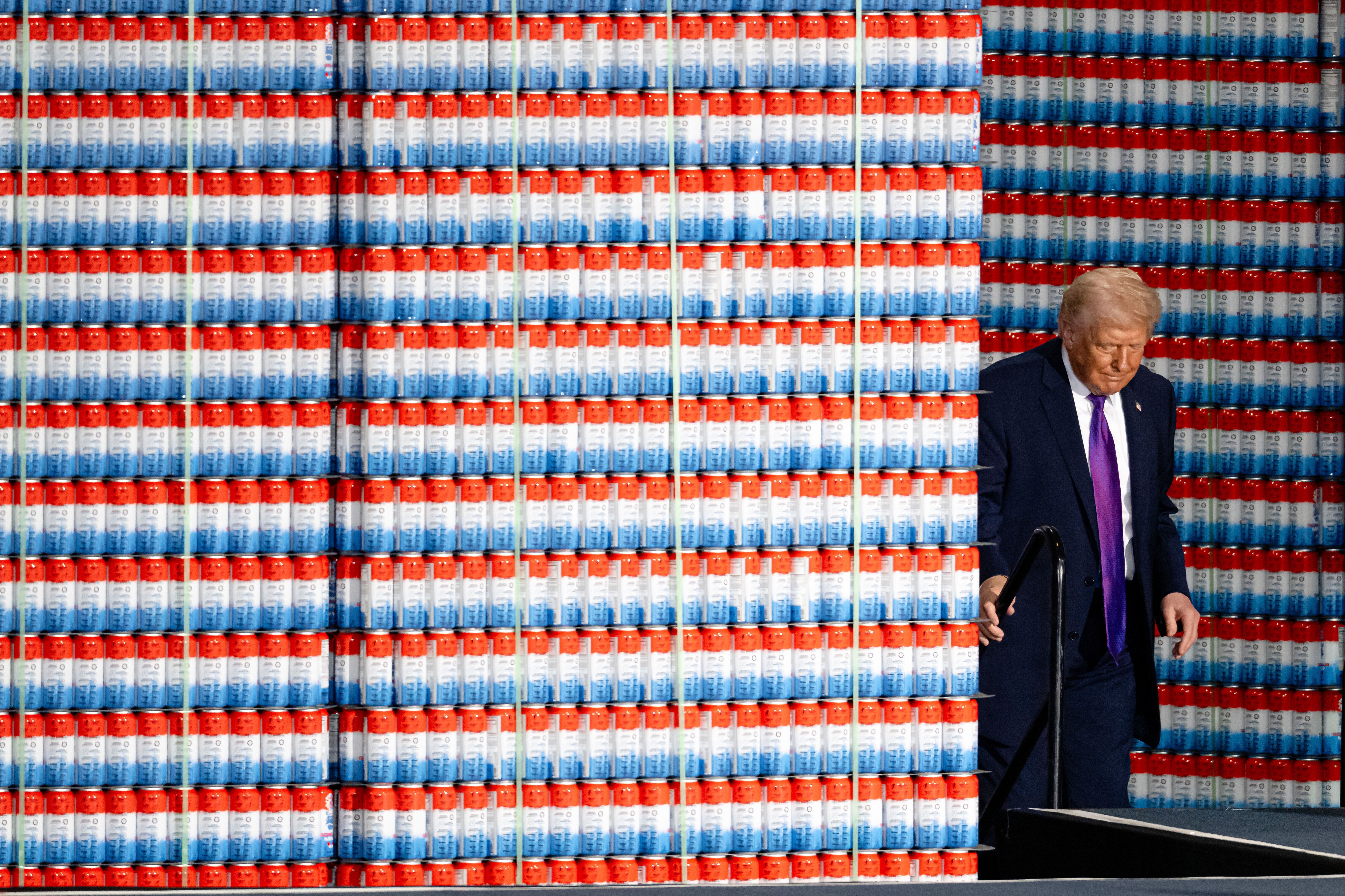 President Trump — surrounded by makeshift walls of aluminum cans — arrives to speak at Verst Logistics in Hebron, Ky., yesterday.