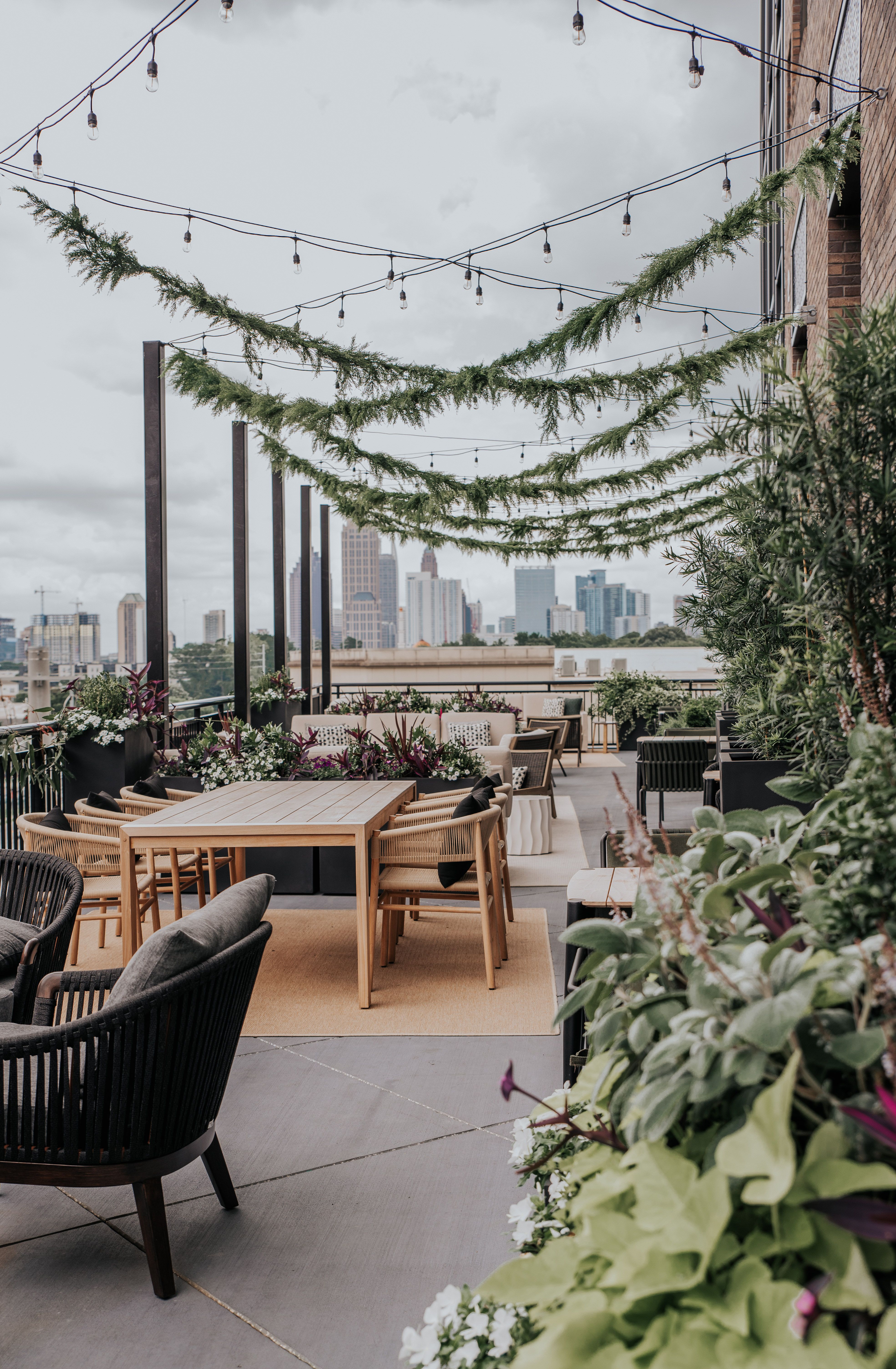 A lush rooftop bar in front of Atlanta skyline
