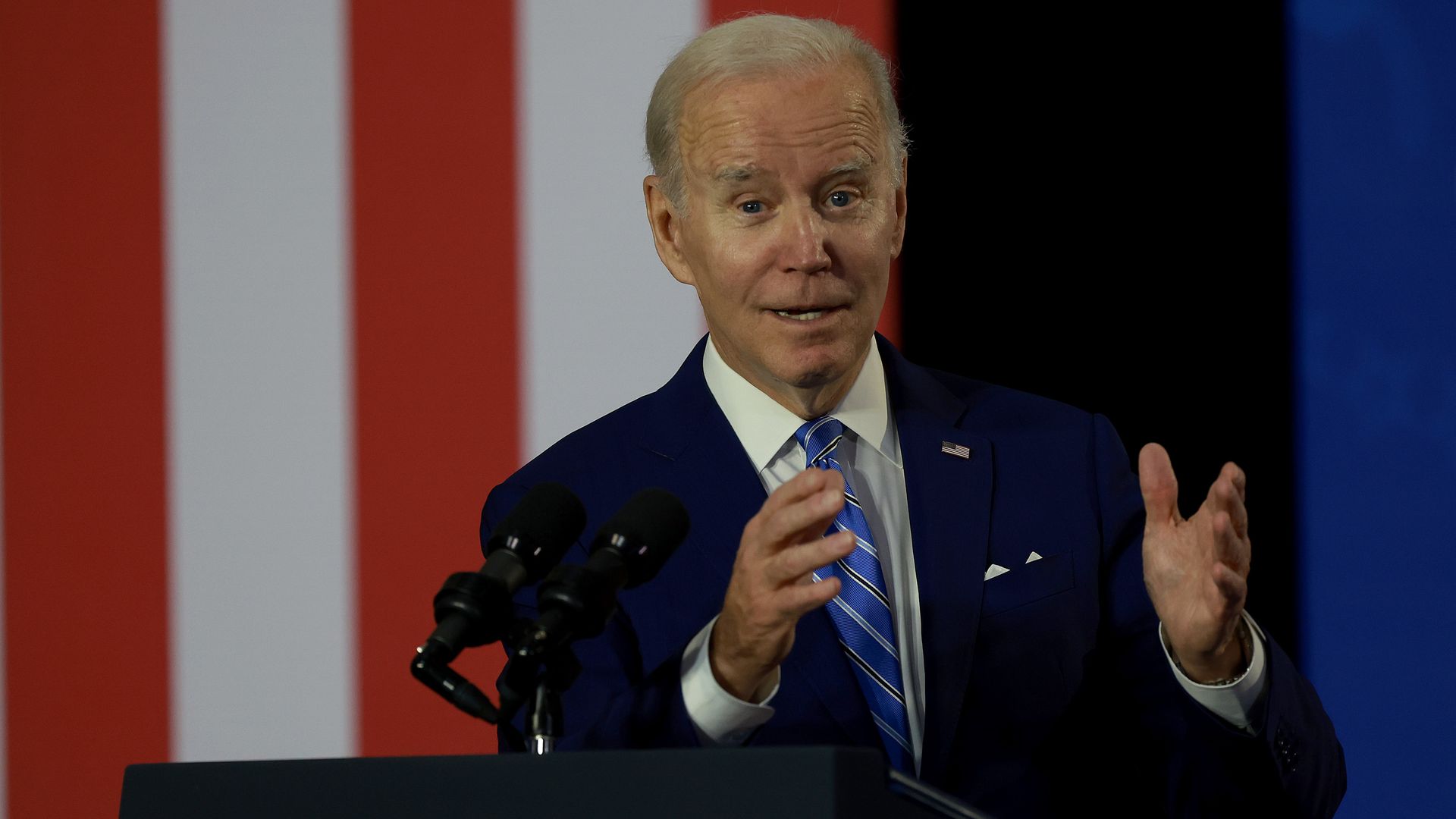 President Biden speaking with an American flag behind him