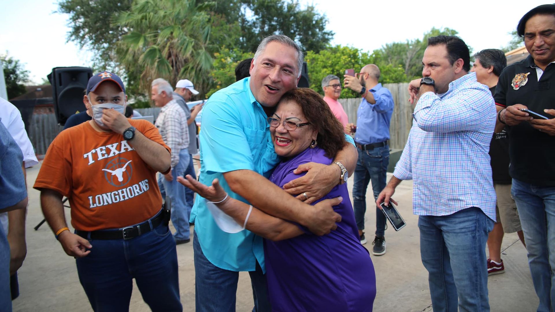 Javier Villalobos hugs a supporter while a man in the University of Texas shirt looks on after Villalobos won a mayoral race in McAllen, Texas.