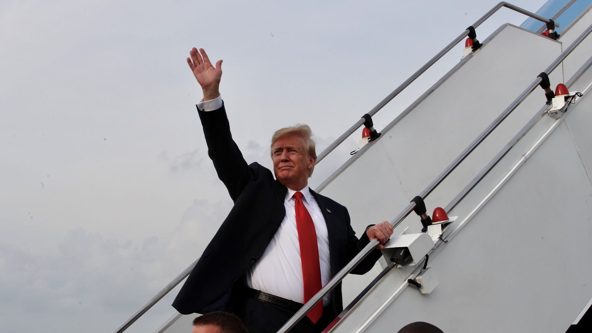 President Donald Trump waving as he gets onto Air Force One.