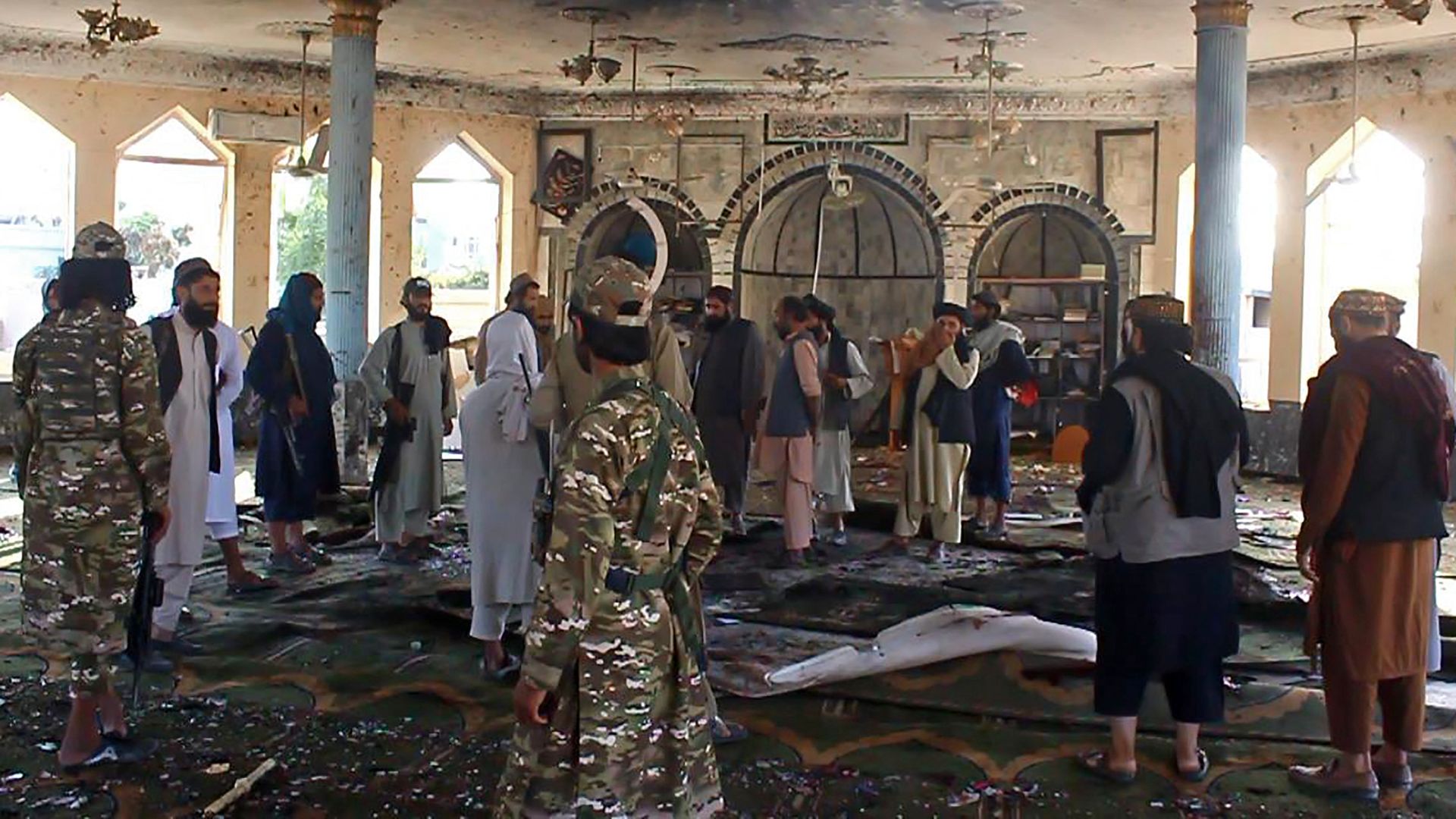 Taliban fighters investigate inside a Shiite mosque after a suicide bomb attack in Kunduz