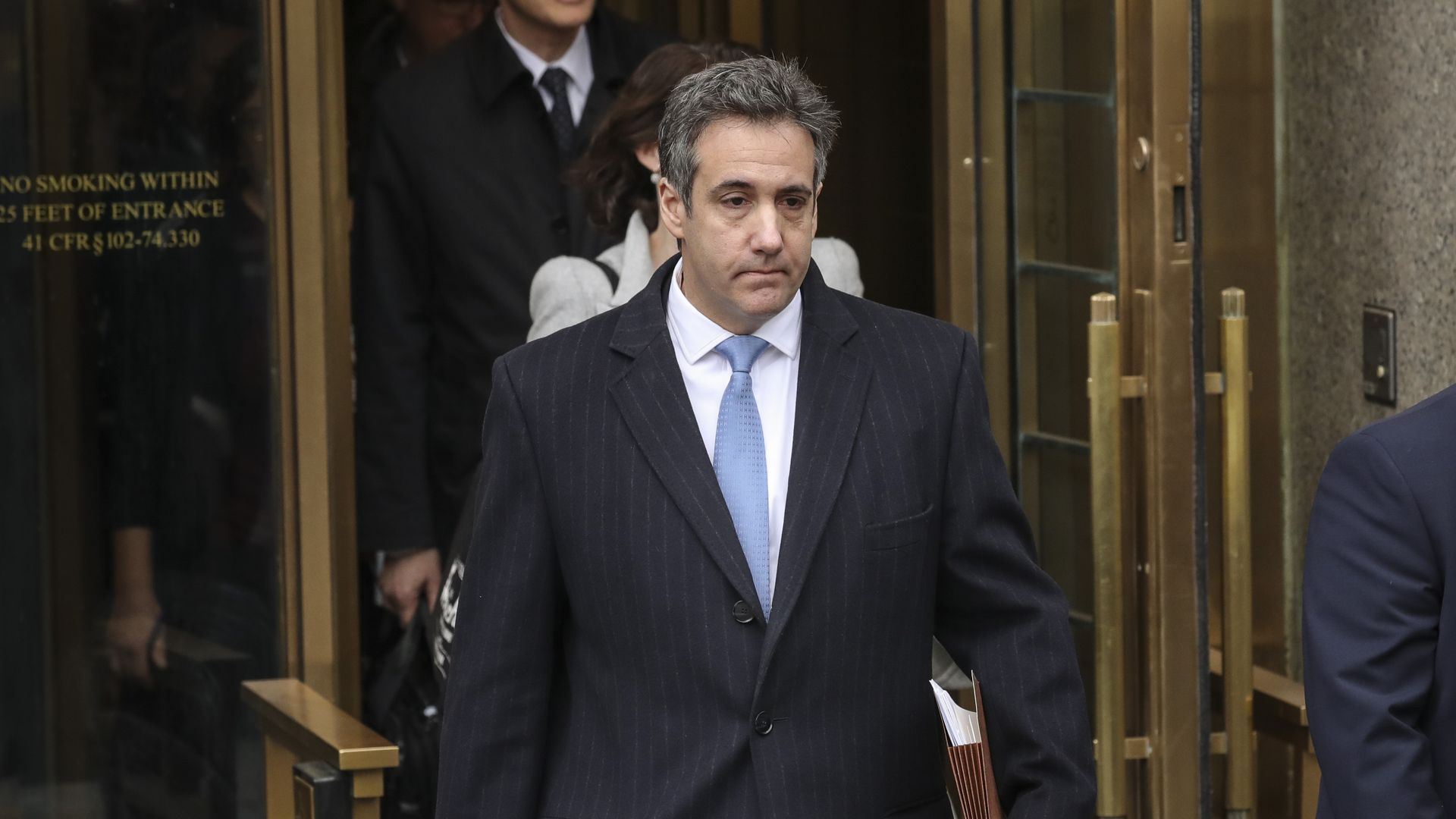 Michael Cohen walks out of a courthouse