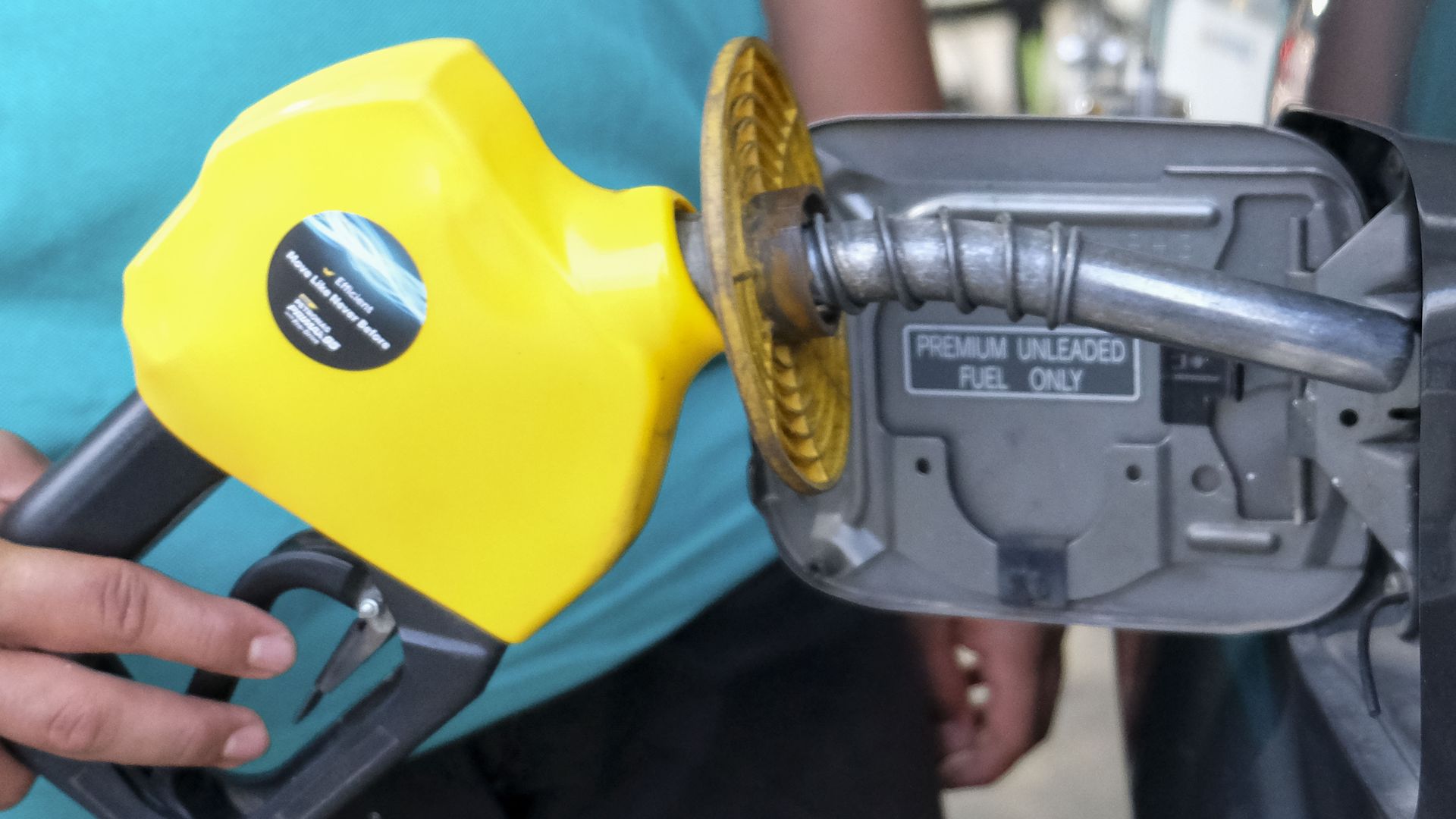A man seen holding the petrol nozzle at a Petronas oil